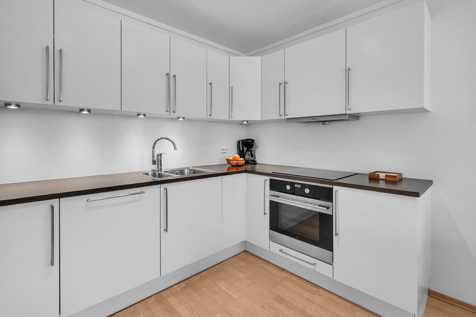 Flott kjøkken med hvite fronter og god skap- og benkeplass Galleribilde