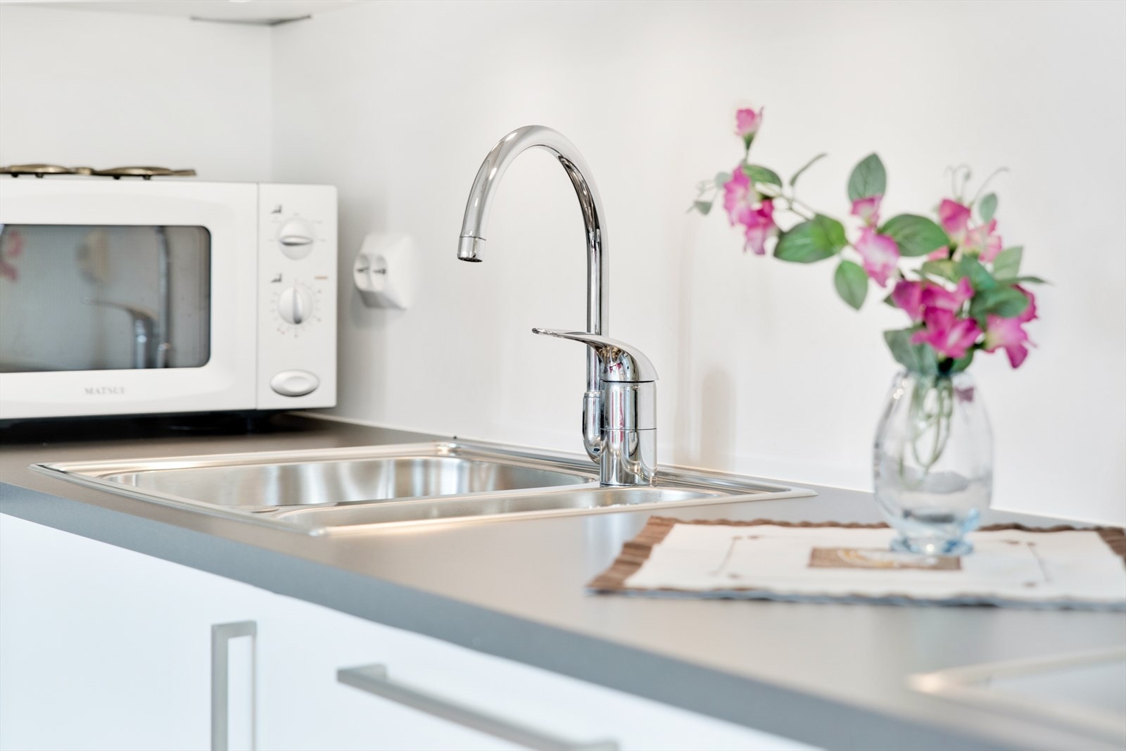 Detalj av den laminerte benkeplaten med nedfelt oppvaskkum i stål. Galleribilde