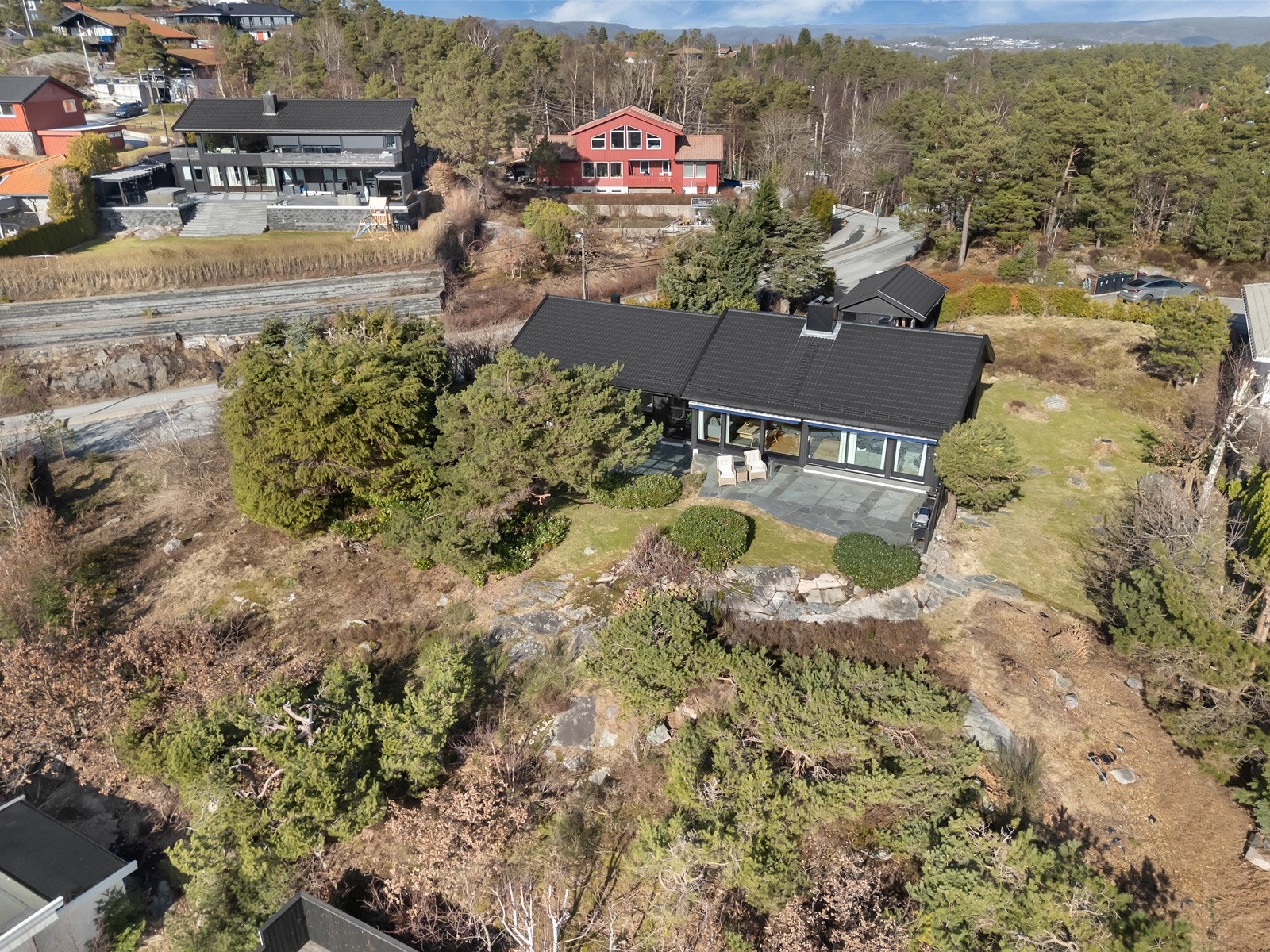 Boligen ligger flott plassert i terrenget på den romslige tomten. Galleribilde