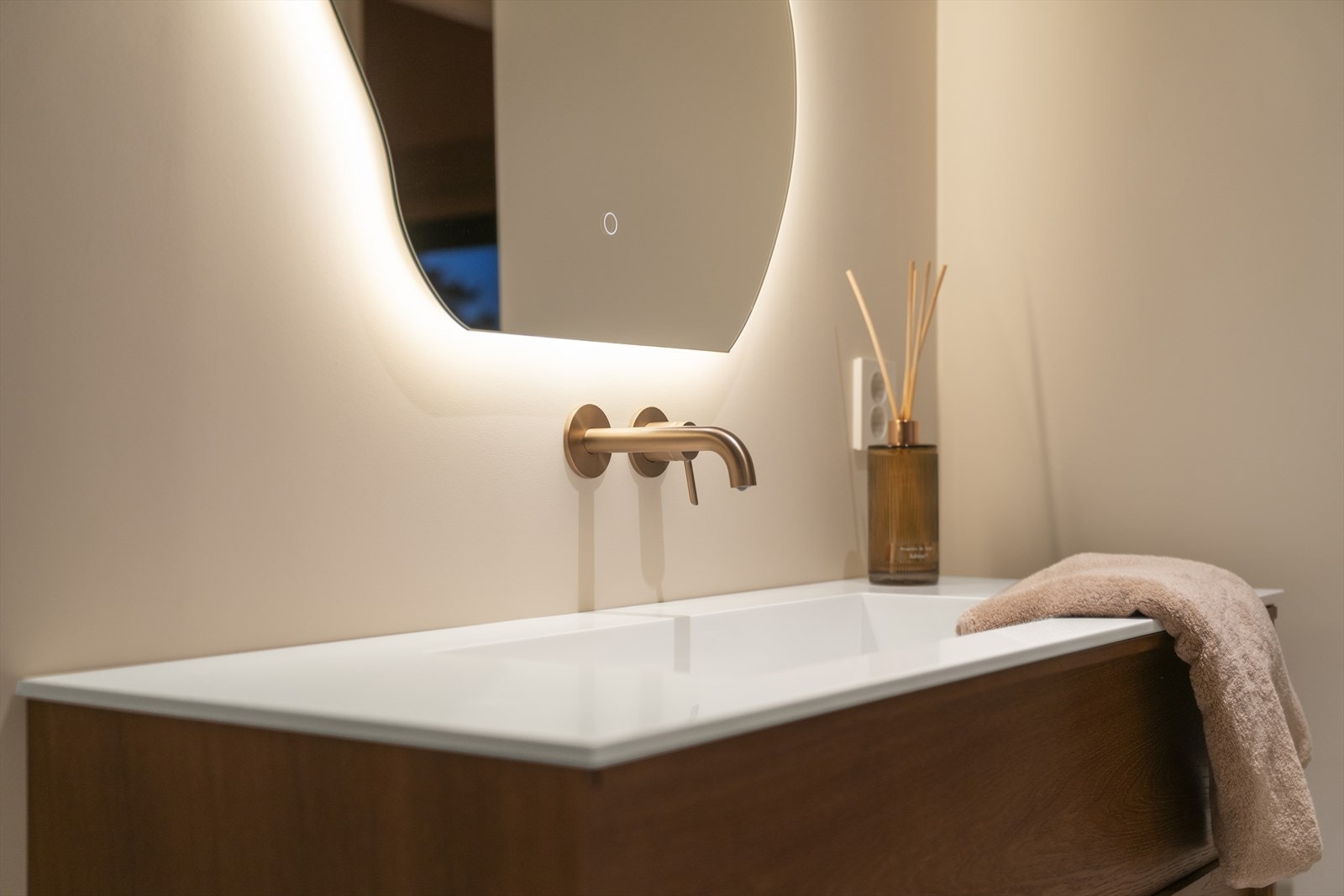 Innredningen består av servant med blandebatteri integrert i vegg, skuffer og speil med integrert belysning Galleribilde