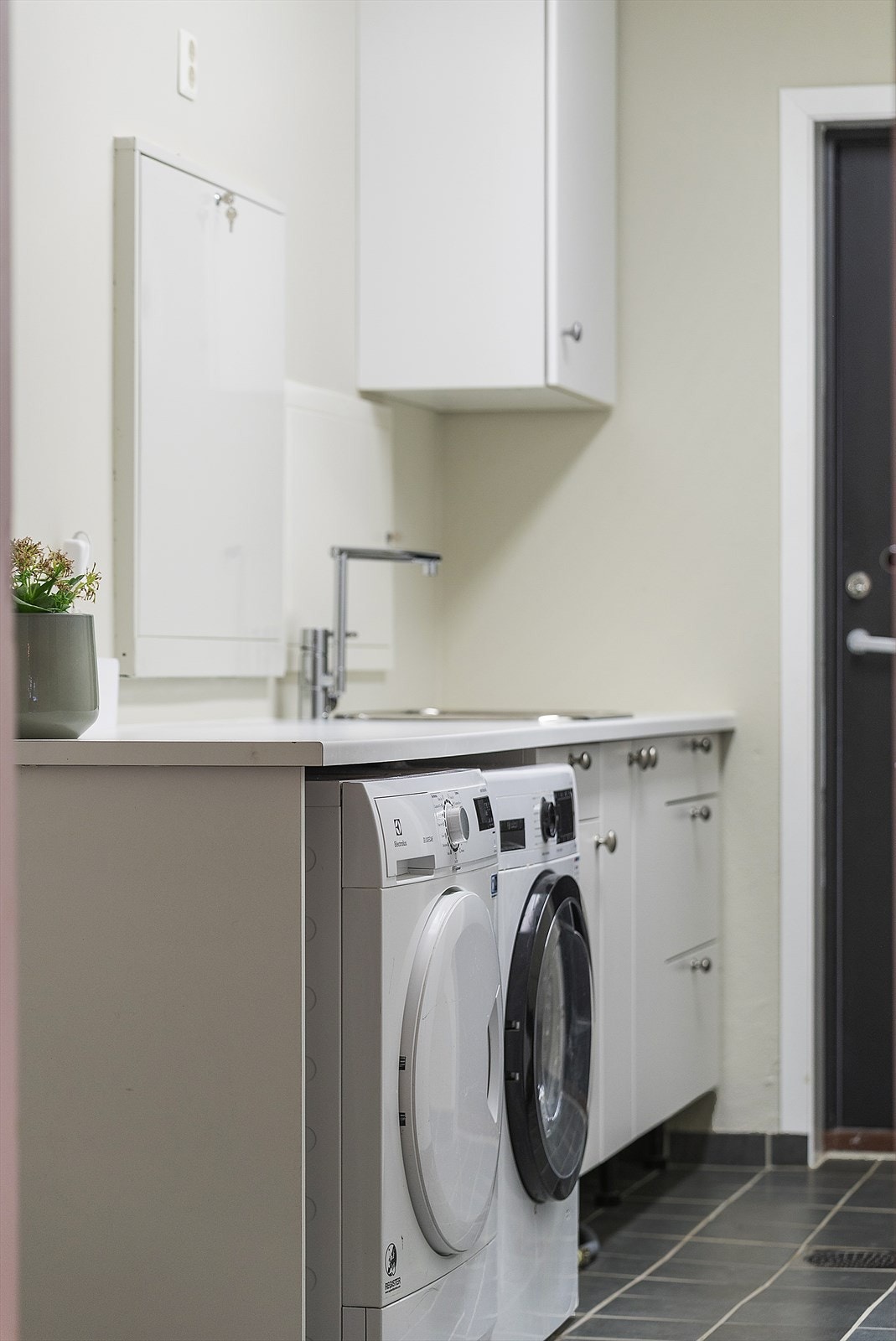 Vaskerommet har benkeplate med utslagvask og plass til vaskemaskin/tørketrommel under, samt flere garderobeskap. Det er integrert strykebrett i den ene skuffen. Galleribilde