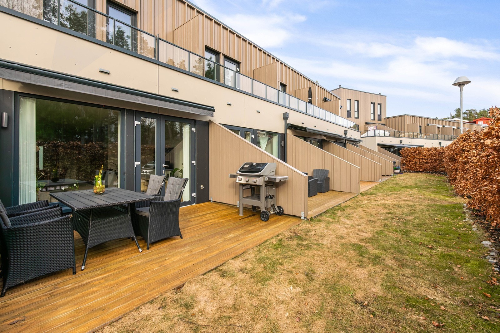 Elektrisk markise på terrassen. Skjermet uteplass med med grilling Galleribilde