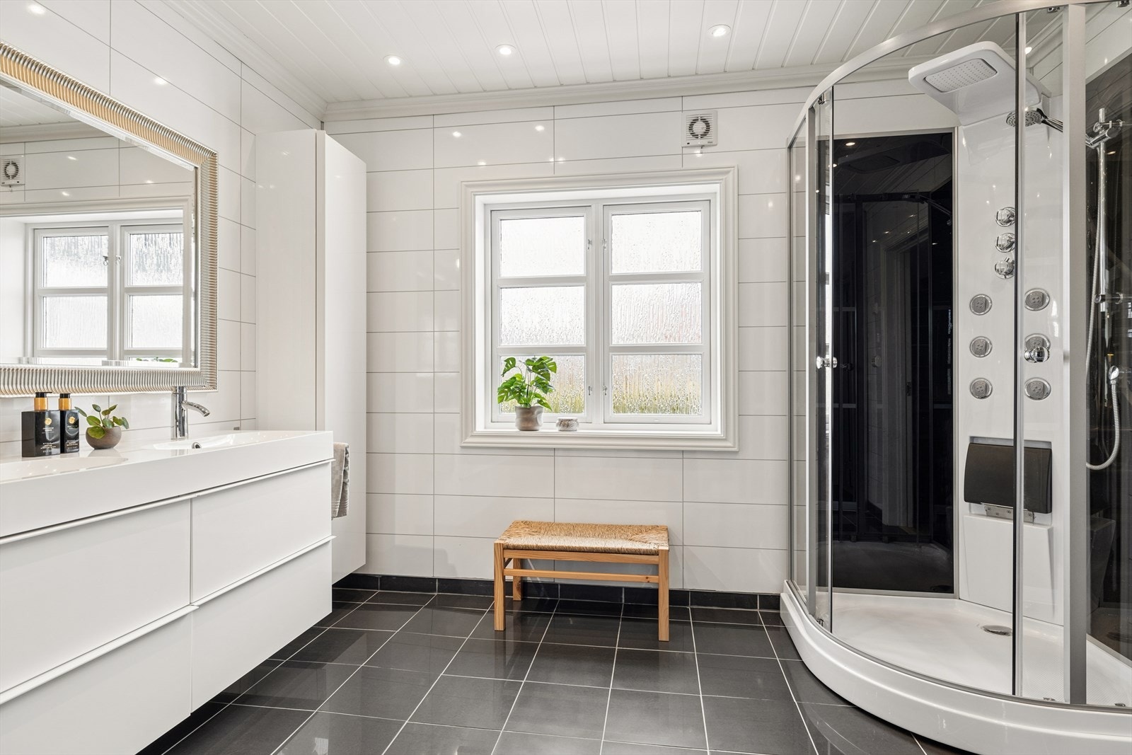 Praktisk, kombinert bad og vaskerom i første etasje fra 2012, utstyrt med dusjkabinett og servantskap. Galleribilde