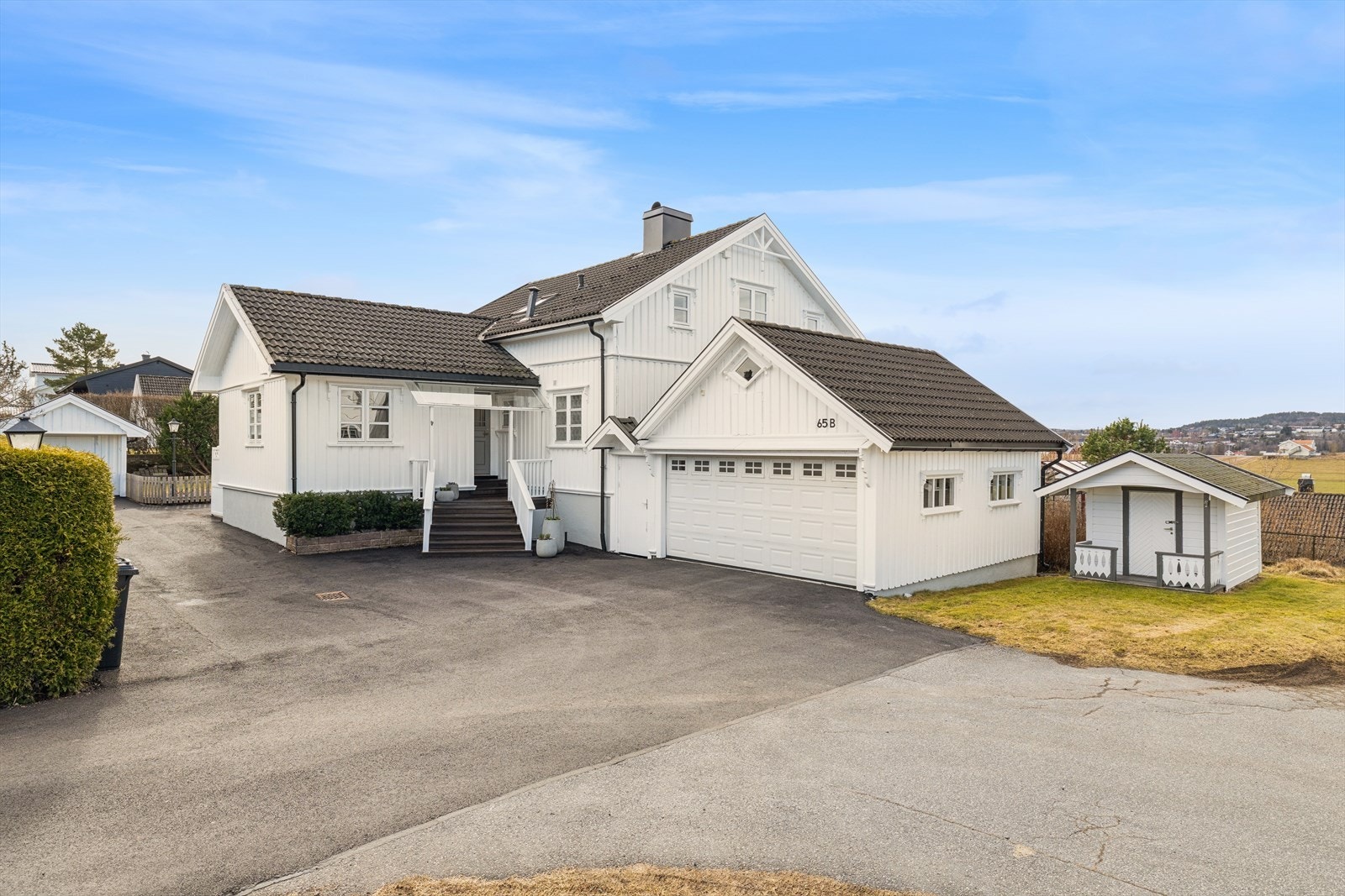 Eiendommen møter deg med en nyasfaltert gårdsplass fra 2025 og integrert garasje. Det er elbil-lader i garasjen. Galleribilde