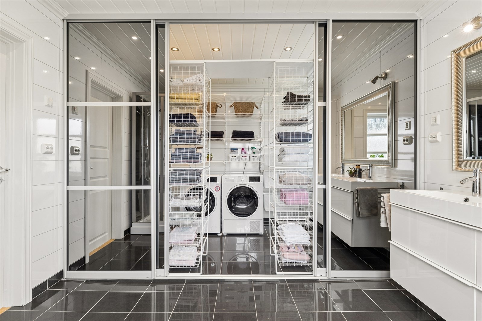 Bak skyvedører med speilfronter er det opplegg for vaskemaskin og gode oppbevaringsløsninger. Galleribilde