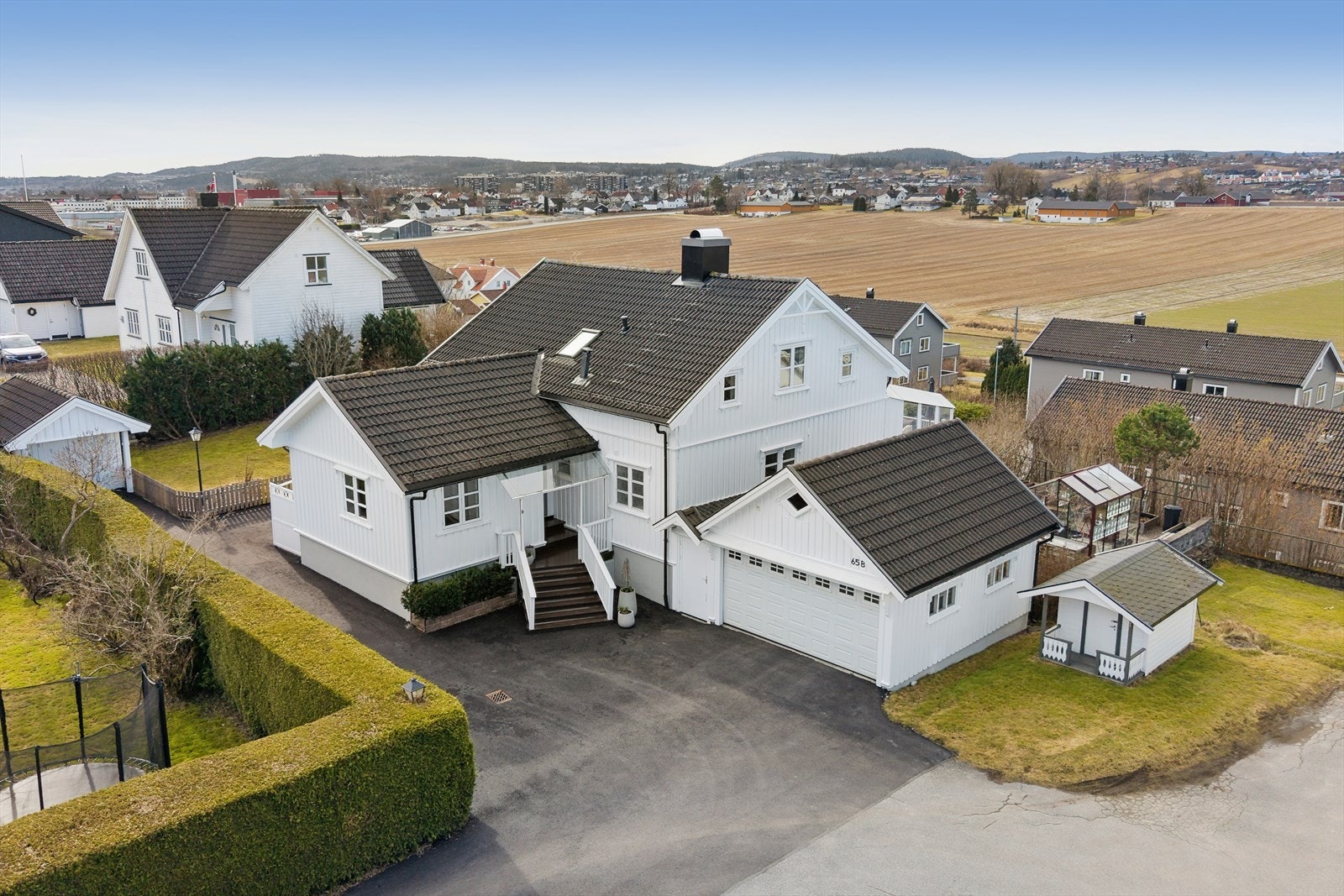 Eiet tomt som er opparbeidet med asfaltert gårdsplass, plen og diverse beplantning. Terrenget rundt boligen er hovedsakelig flatt. Galleribilde