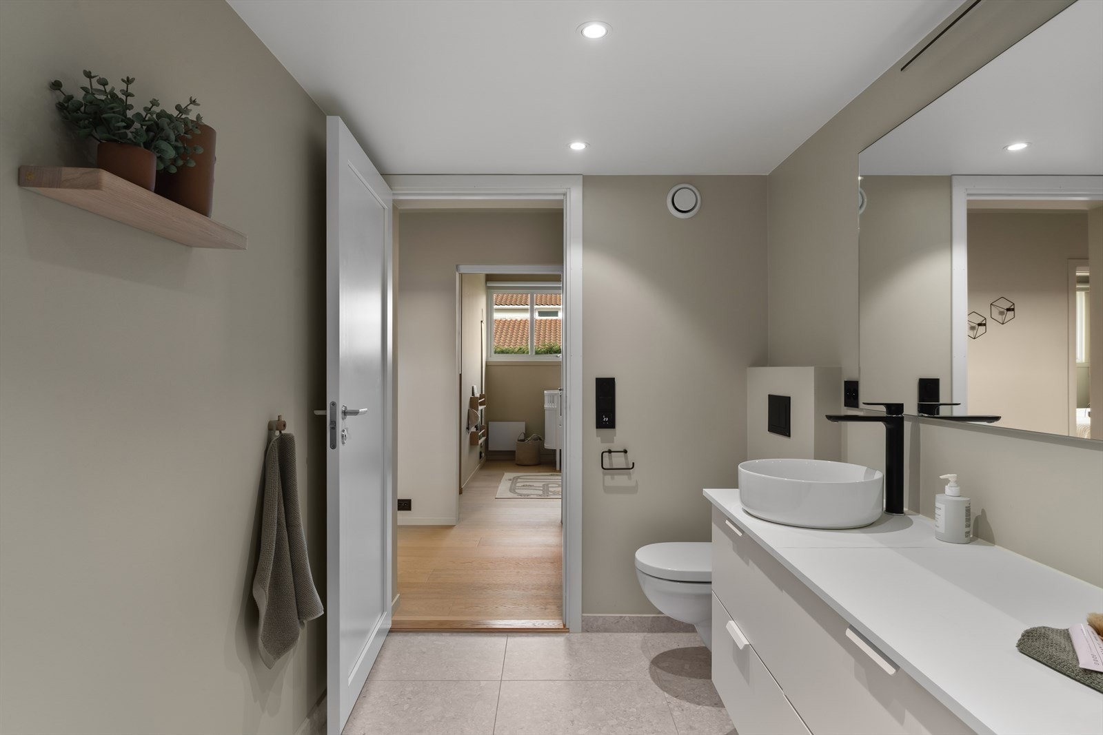 Badet er innredet med vegghengt wc, dusjhjørne og pen seksjon med vask. Opplegg for vaskemaskin Galleribilde