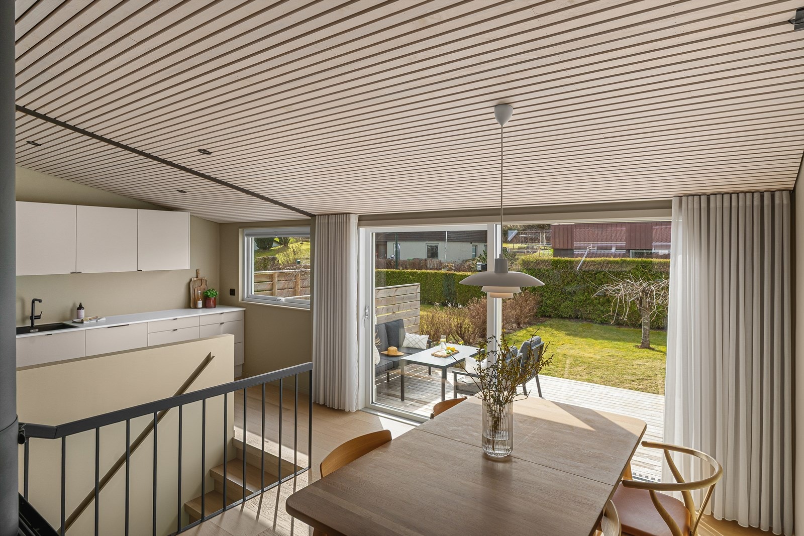 Et par trappetrinn ned finner man spisestuen og kjøkkenet med direkte utgang til den solvendte uteplassen Galleribilde