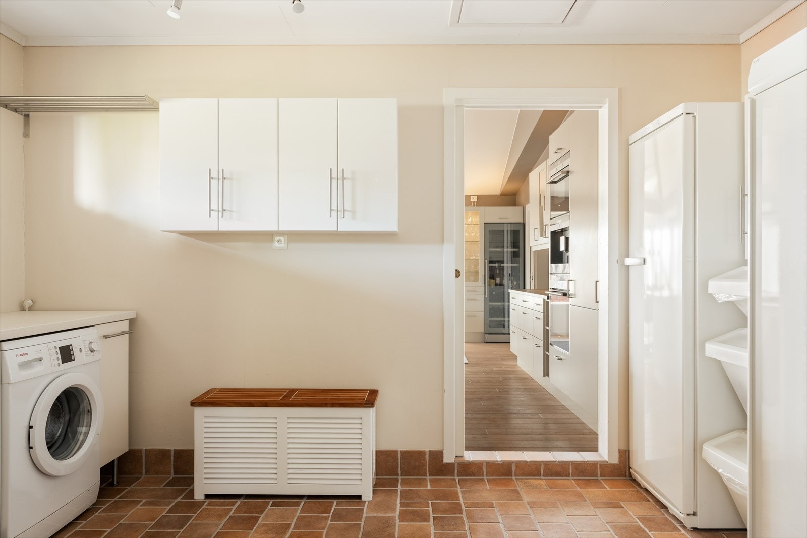 Fra kjøkkenet er det videre adkomst til et romslig og praktisk vaskerom, utstyrt med benkeplate, nedfelt skyllekar og opplegg for vaskemaskin Galleribilde