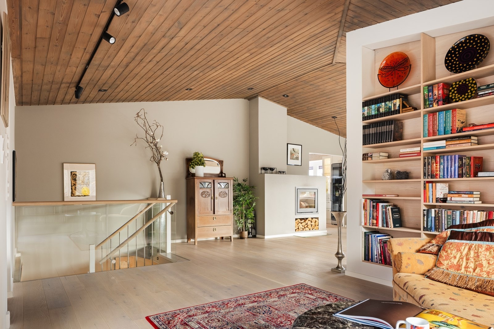 Rommet deles naturlig av med en stilren bokhylle Galleribilde