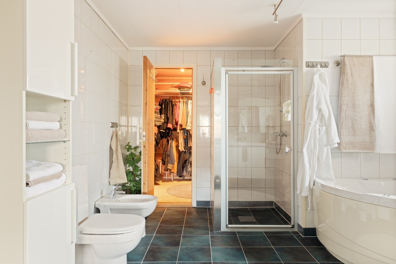 Badet er romslig og er utstyrt med badekar, dusj, toalett, bidé og baderomsmøblement med dobbel servant Galleribilde