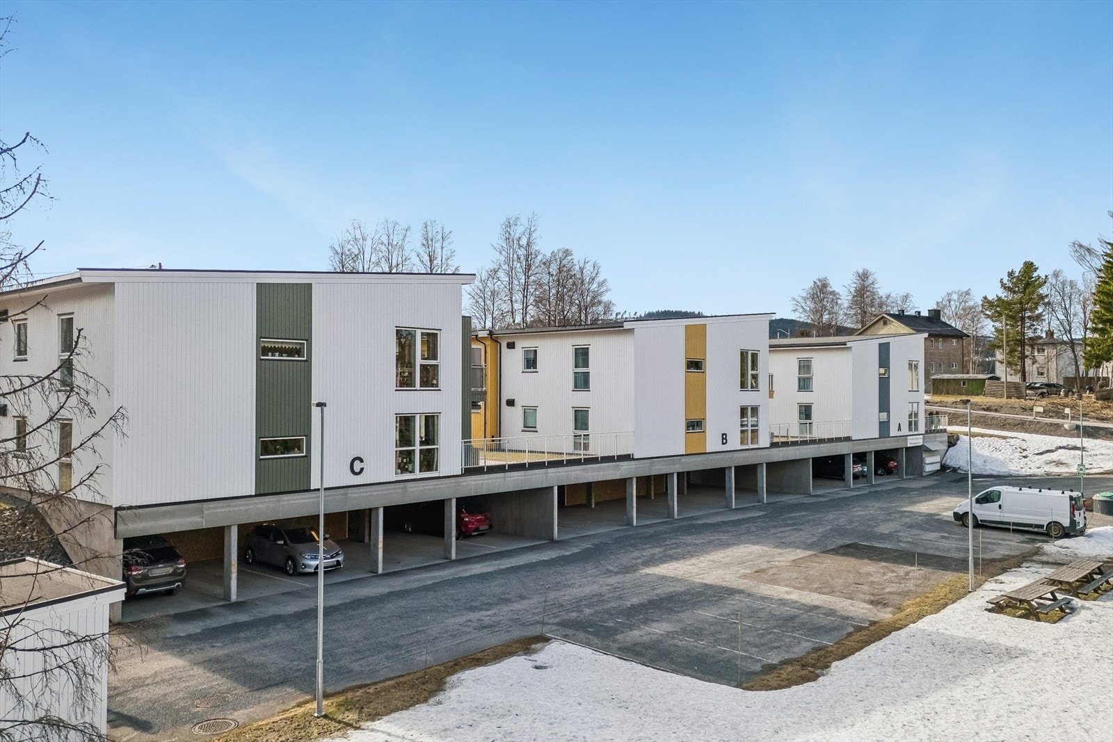 Leiligheten ligger i Kortabakken borettslag, et boligbygg fra 2020 med moderne fasader og parkering i underetasjen. Galleribilde
