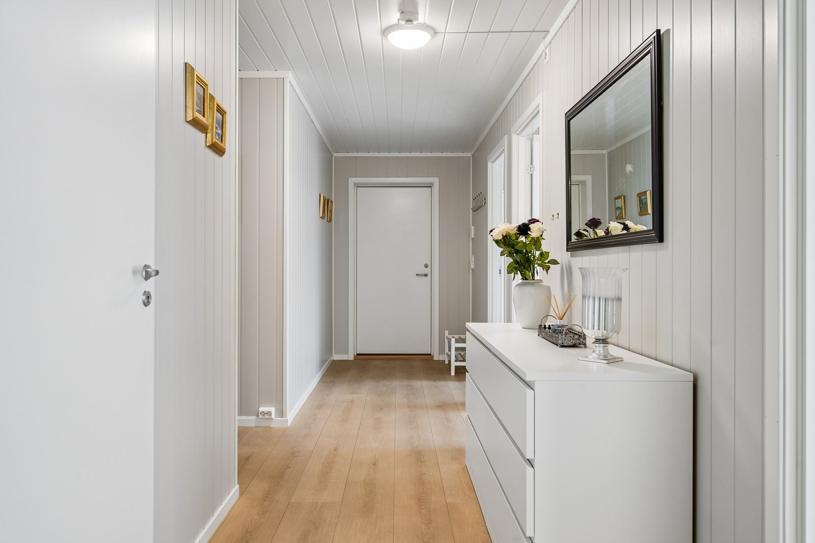 Entréen gir et godt førsteinntrykk med laminat på gulv og panelplater på veggene, som er gjennomgående i flere rom. Galleribilde