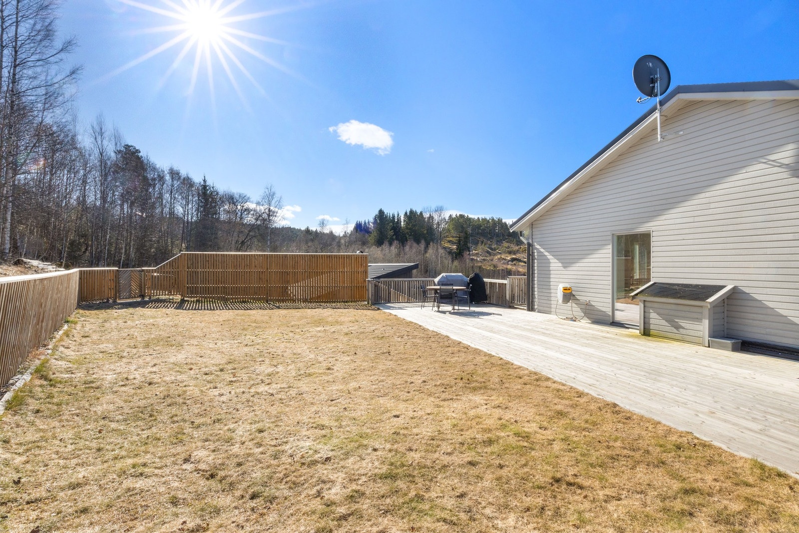 Stor terrasse og planert gressplen på baksiden av huset. Galleribilde