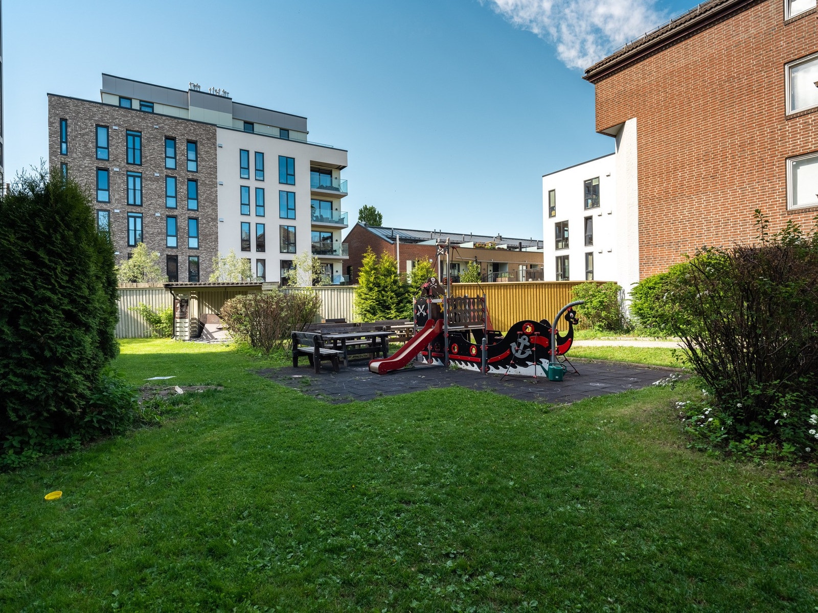 De har en pent opparbeidet tomt som er svært barnevennlig. Her er det hyggelige sittegrupper, lekeplass for de minste og en flott beplantet hage. Galleribilde