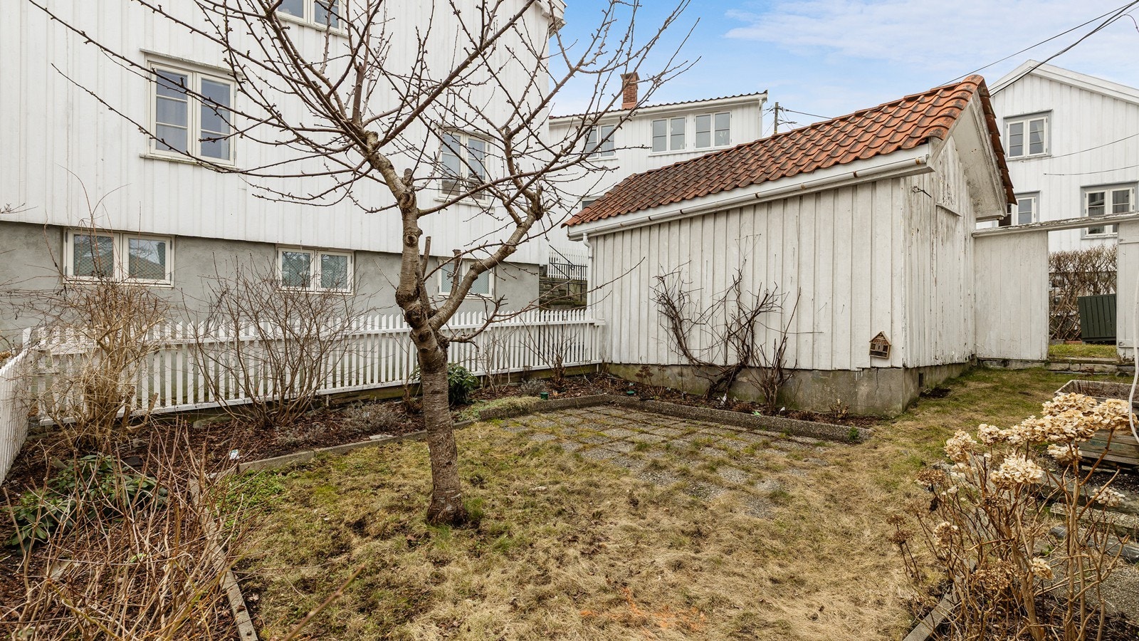 Hagen er pent opparbeidet med bed og plen. Galleribilde