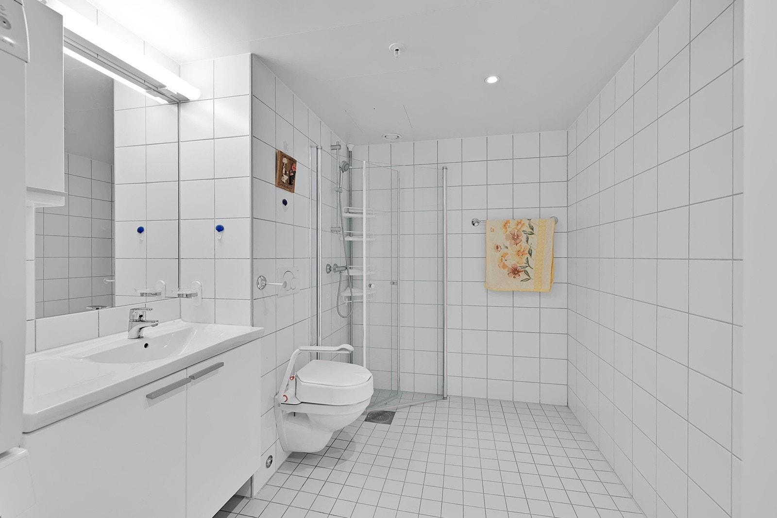 Dusjhjørne, veggopphangt wc, servant med over/underskap og opplegg til vaskemaskin. Galleribilde