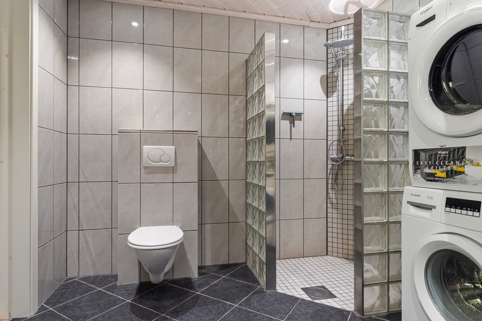 Av utstyr finnes varmekabler i gulv, opplegg for vaskemaskin, dusjhjørne, klosett, servant og garderobeskap. Galleribilde