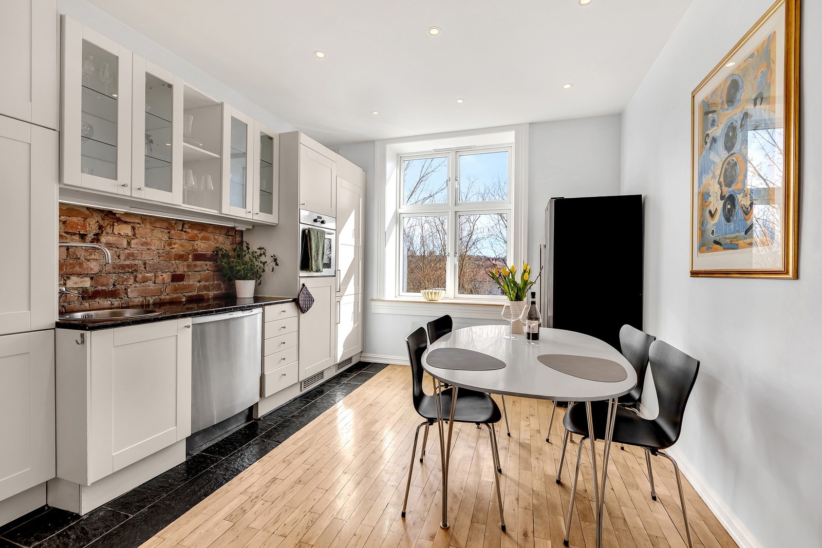 Kjøkkenet har tidløs innredning med hvite profilerte fronter og enkelte glassfronter i overskap. Galleribilde