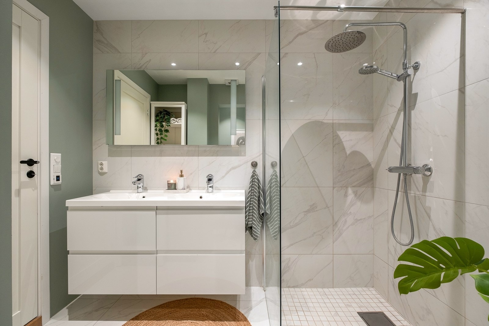 Boligen har et delikat baderom som følger leilighetens moderne stil med store, lyse fliser og downlights i tak. Galleribilde