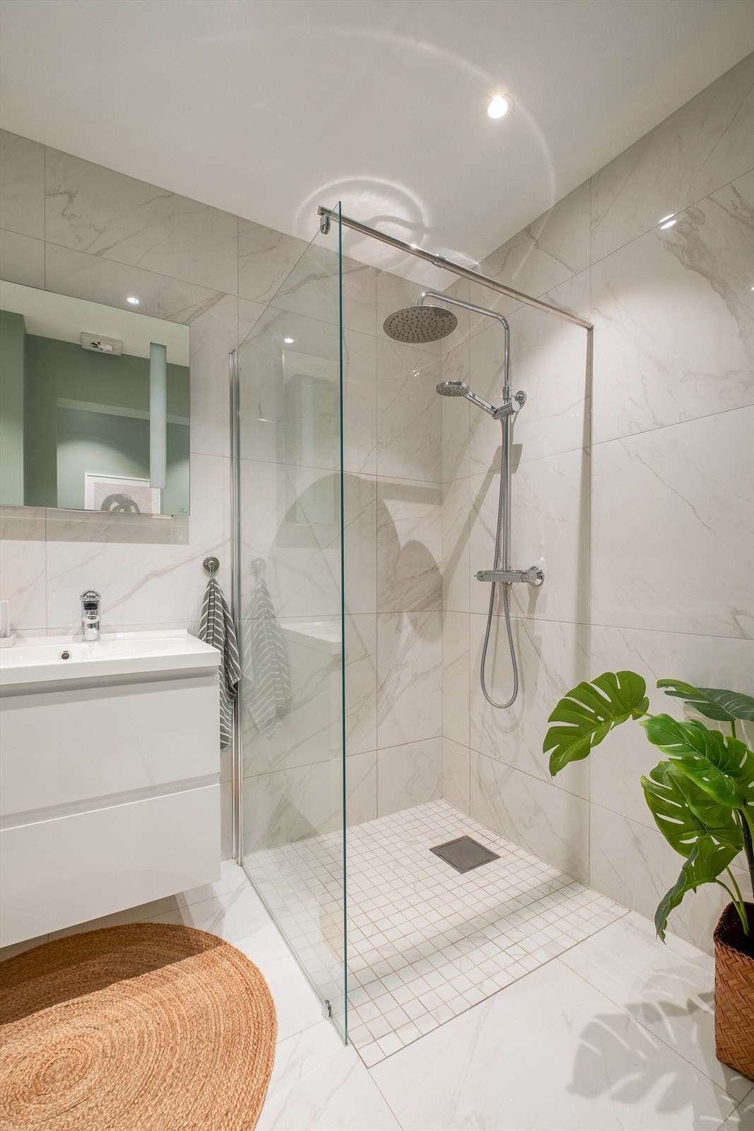 Badet er moderne og innredningen består av servantinnredning, vegghengt toalett og dusjhjørne med regndusj. Galleribilde