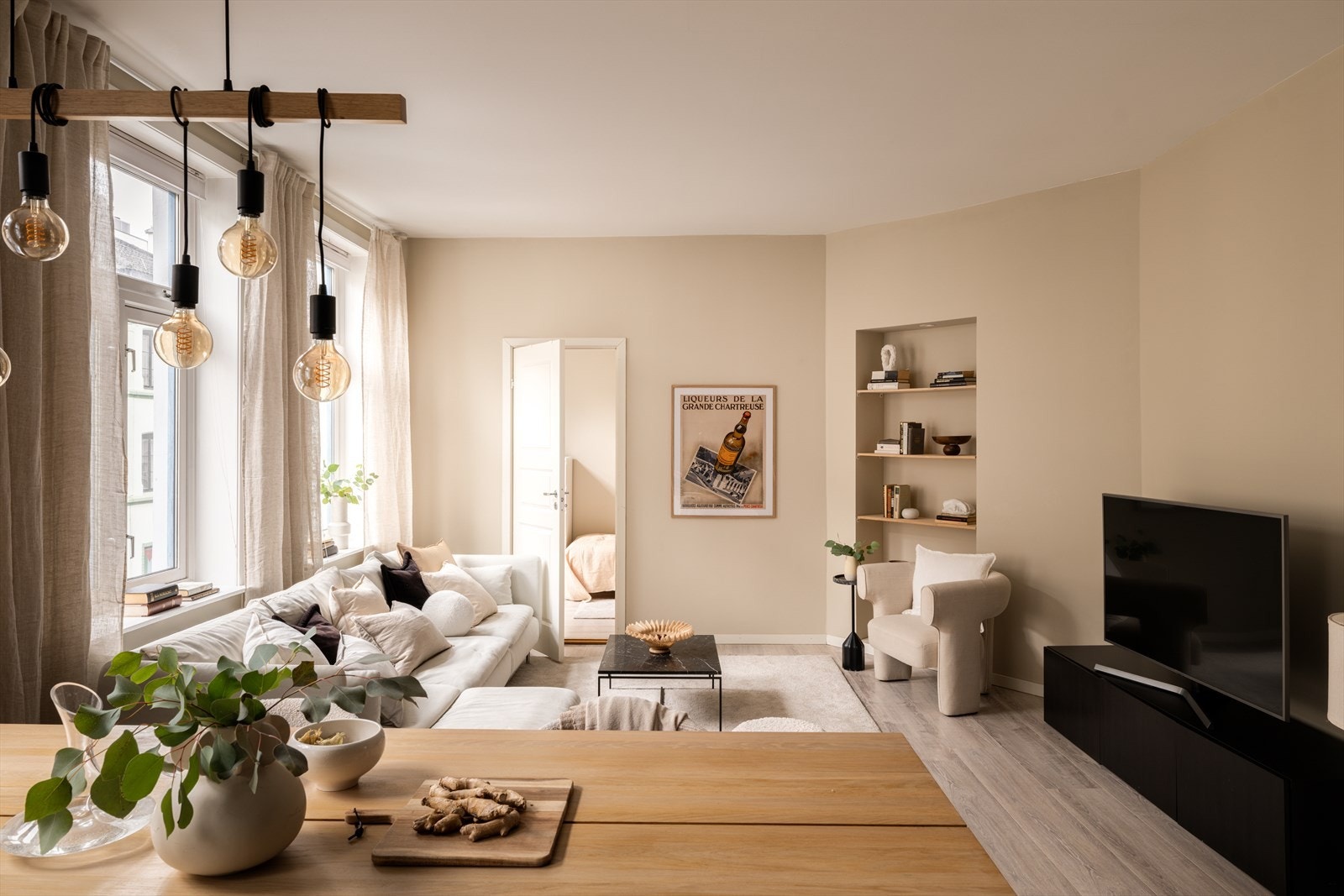 Stuen er lett å møblere med god plass til både sofagruppe og spisebord. En innfelt hylle-nisje gir en stilren oppbevaringsløsning. Galleribilde