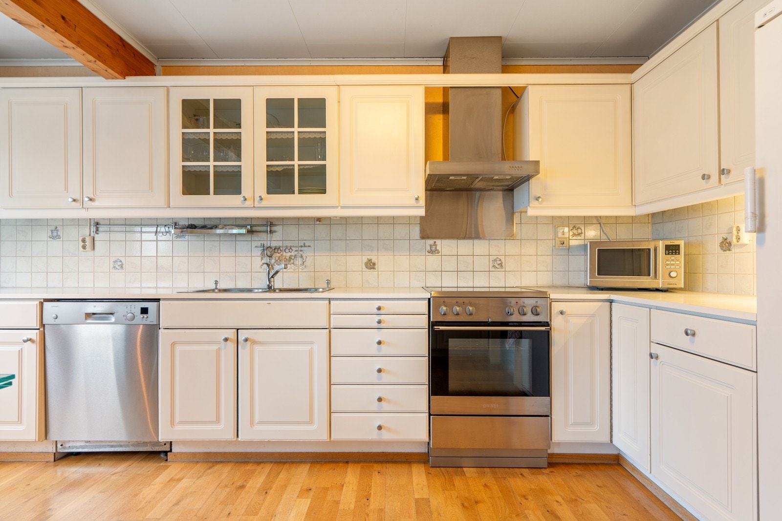 Kjøkken med hvit kjøkkeninnredning med profilerte fronter, god med skap og benkeplass. Samt god plass for spisebord på kjøkken. Utgang til terrassen også fra kjøkken. Galleribilde