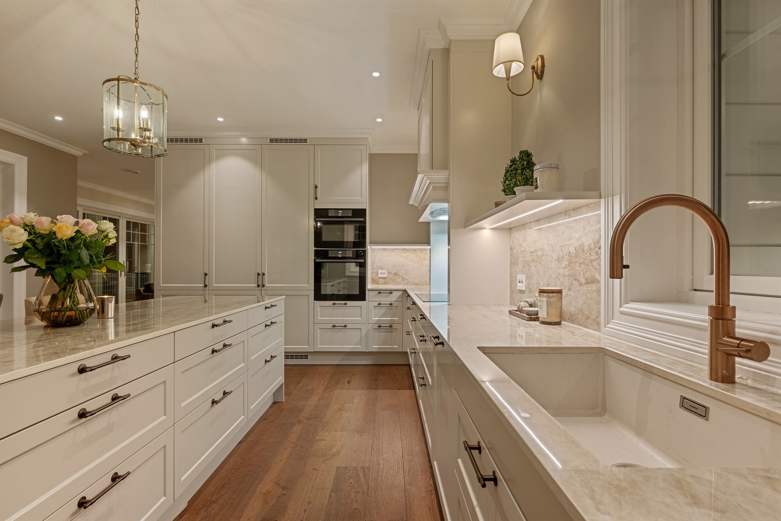 Moderne kjøkken i åpen løsning med innredning fra Nybo, påkostet Dekton benkeplate og gjennomførte materialvalg. Galleribilde