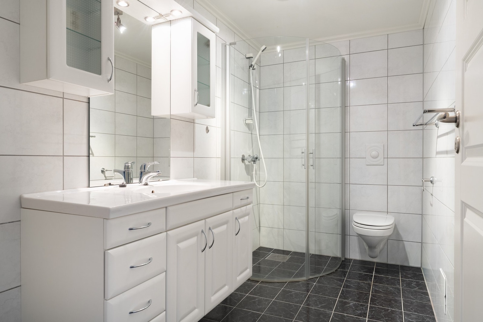 Det er innredet med vegghengt toalett, dusj med glassfoldedør, servant med møblement, speil og belysning. Det er vannbåren gulvvarme. Galleribilde