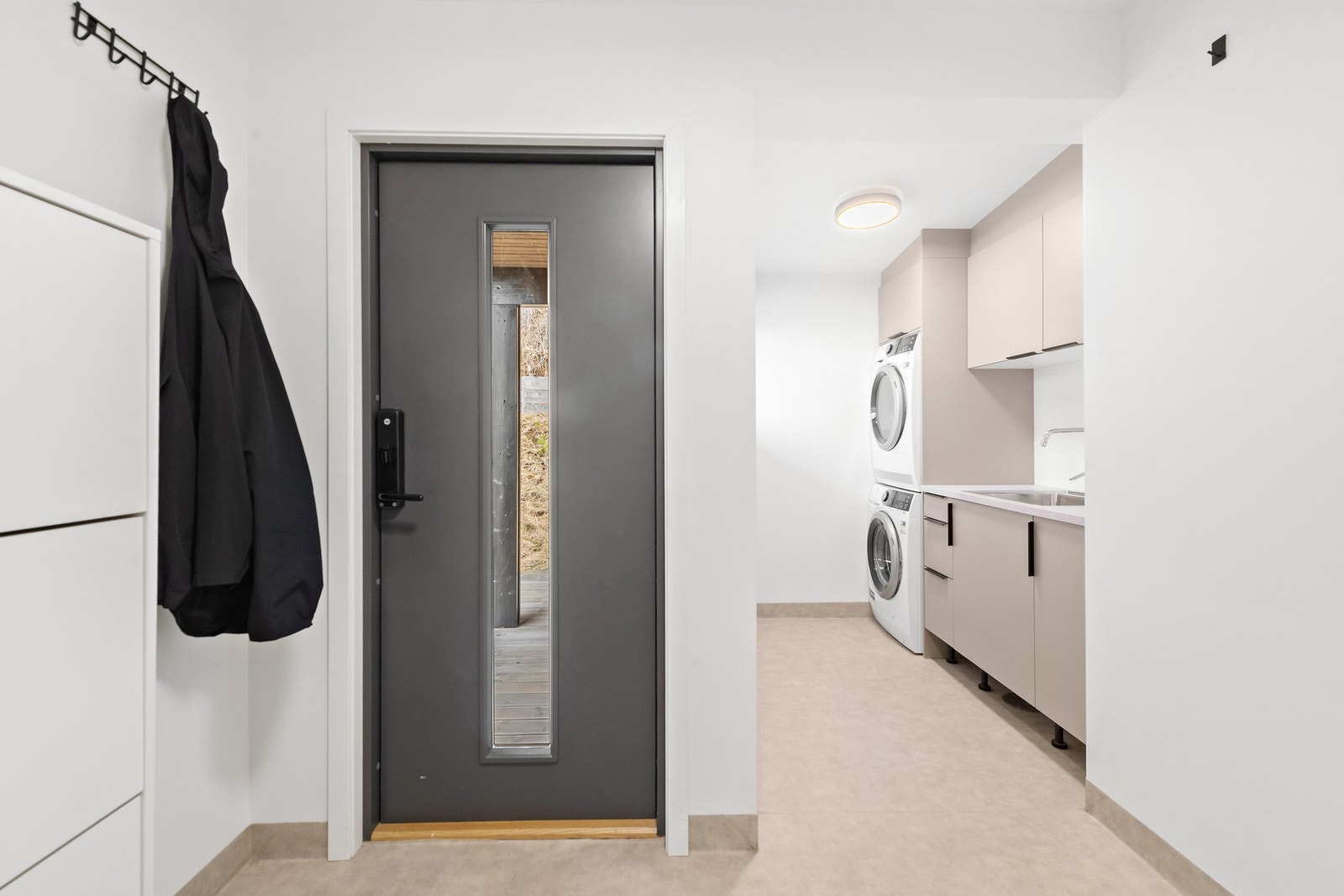 Vaskerom fra 2023 med vaskeromsinnredning med glatte, malte fronter og laminat benkeplate. Galleribilde