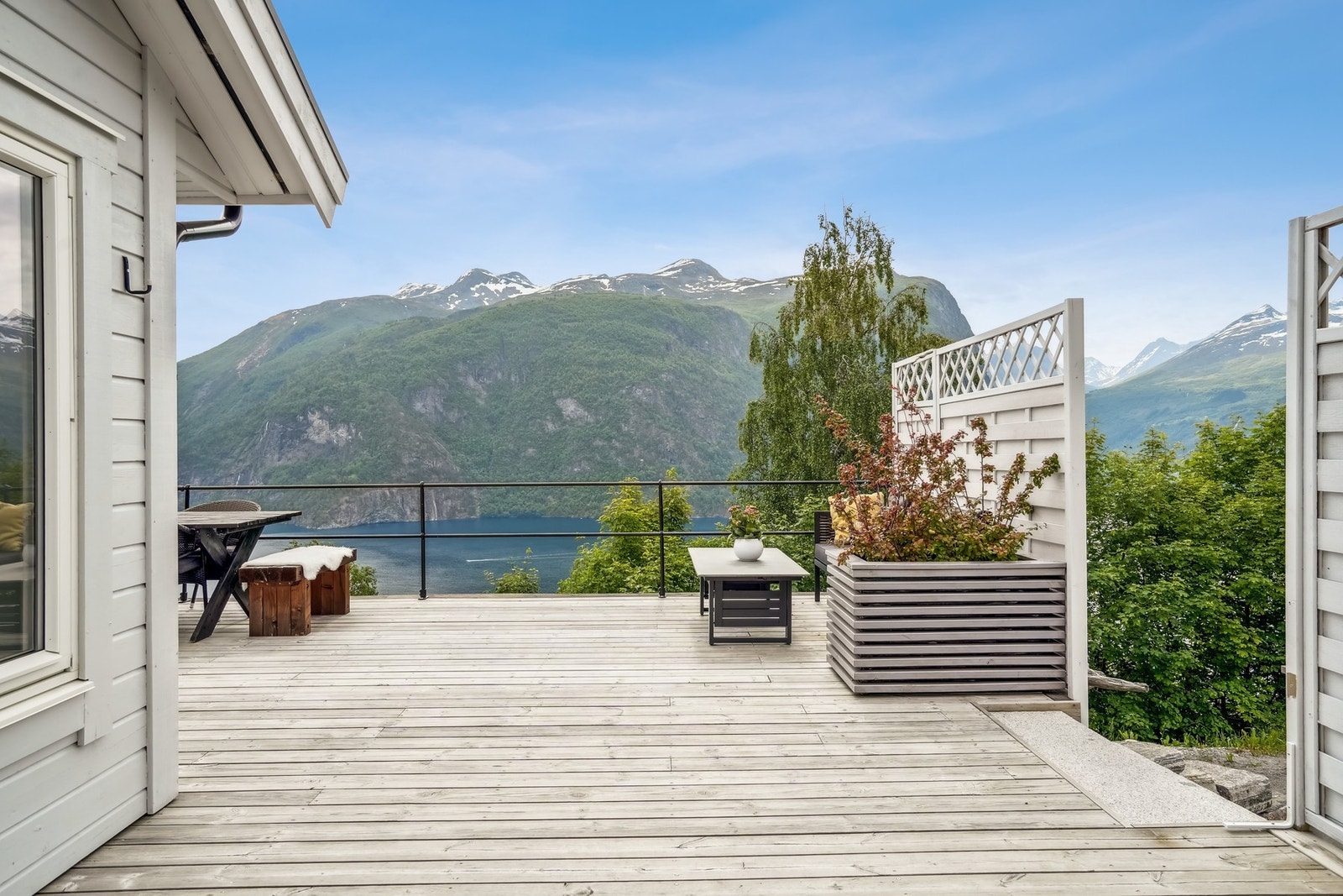 Solrik terrasse på ca. 80 kvm belagt med terrassebord og rekkverk i smijern. Galleribilde