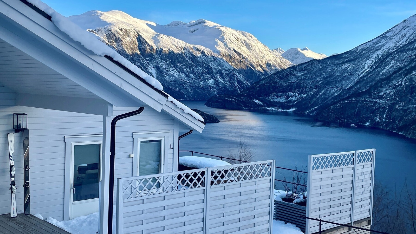 Der snødekte topper møter dypblå fjord. Galleribilde