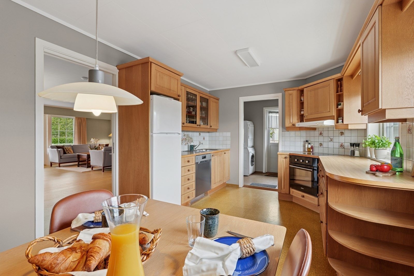 Kjøkkenet er fra byggeår, levert av Huseby og innredet med trefargede, profilerte fronter og trefarget benkeplate i laminat. Her har man godt med skap- og skuffeplass, samt gode arbeidsflater på benk. Galleribilde