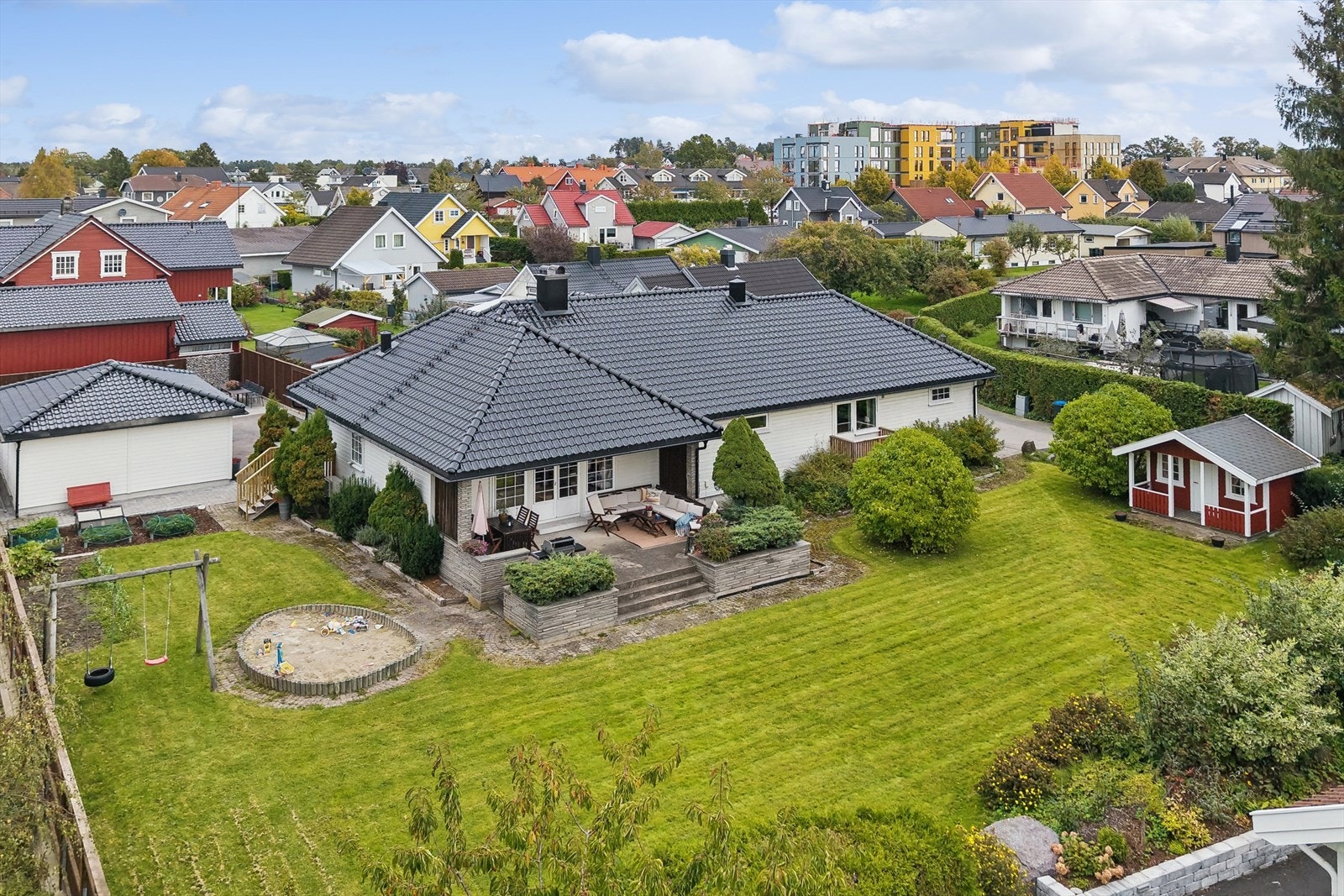 Eiendommen er flott opparbeidet med en stor hage som gir god boltreplass for store og små. Hagen er pent beplantet med ulike prydbusker og har i tillegg grønnsakshage, lekehytte og sandkasse for de minste i familien. Galleribilde