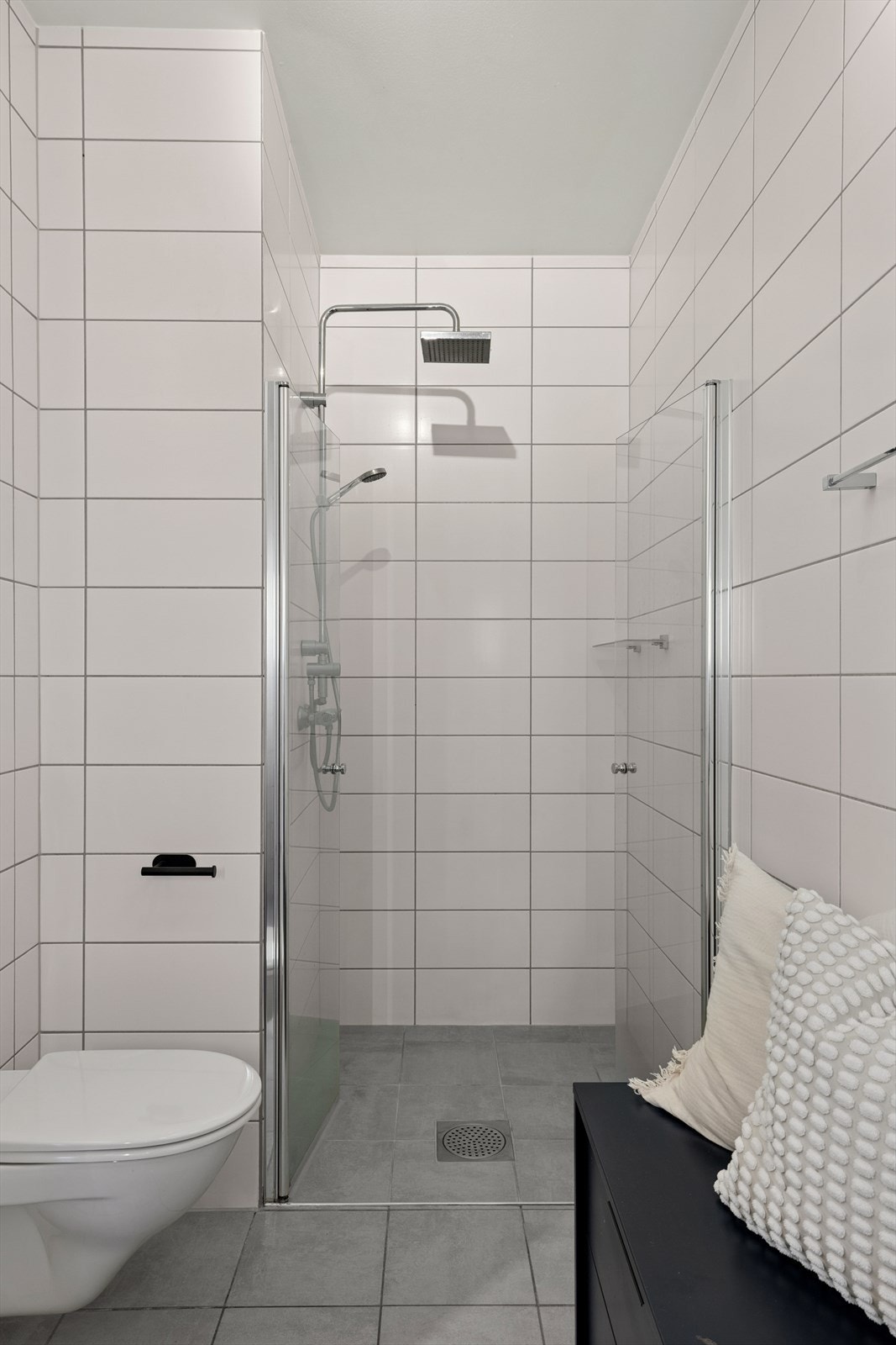 Rommet er utstyrt med vegghengt toalett, servant med innredning, speil med belysning og dusj med innfellbare glassdører og ventilasjon via avtrekksventil. Galleribilde