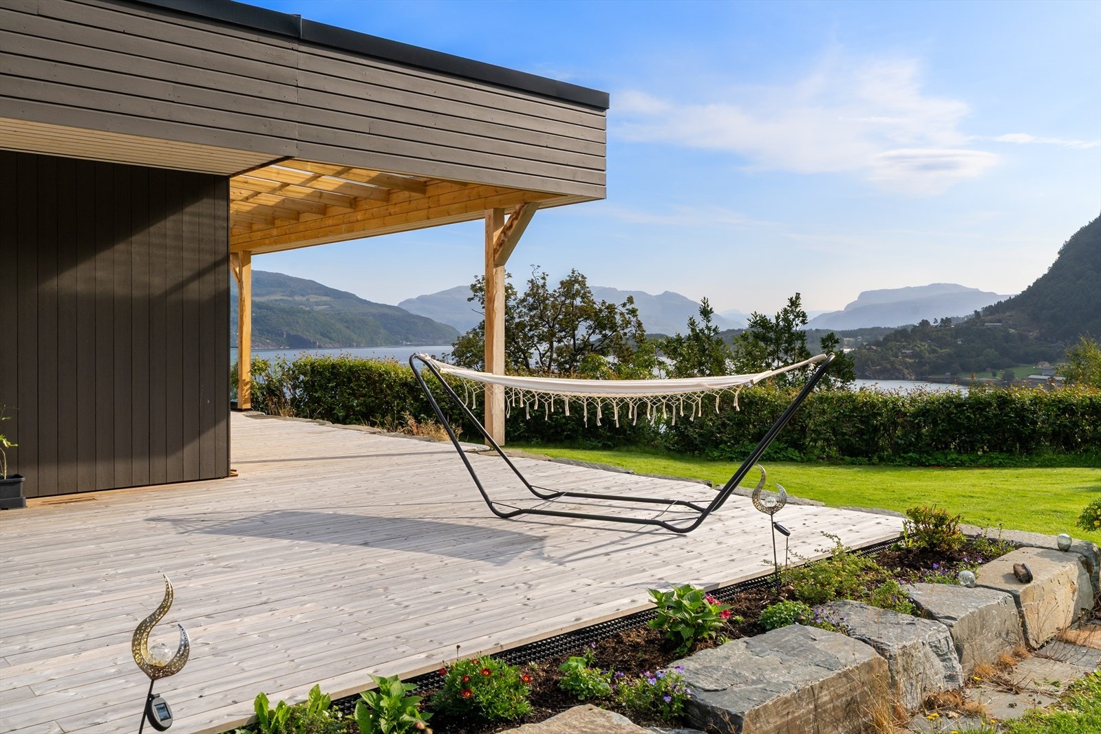 Område rundt våningshuset er opparbeidet hage med støttemurer, terrasser, belysning og fast dekke i gårdsrom. Galleribilde