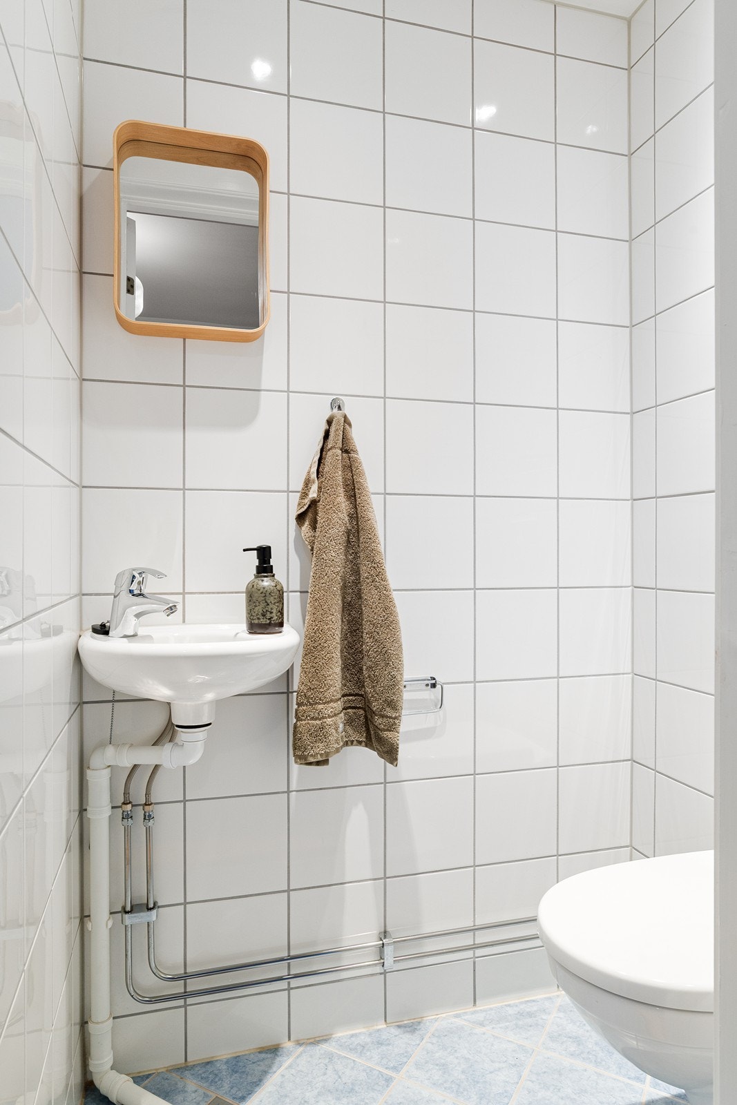 Separat, helfliset toalettrom, innredet med toalett og vegghengt servant Galleribilde