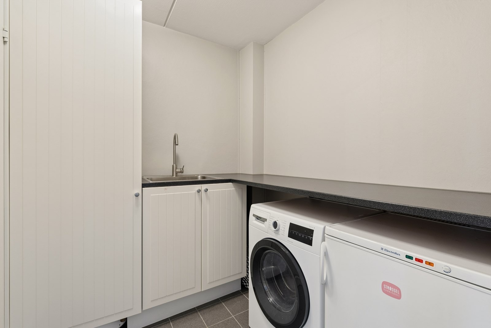 Vaskerommet er utstyrt med flislagt gulv, malte vegger og himling, samt opplegg for vaskemaskin. Galleribilde