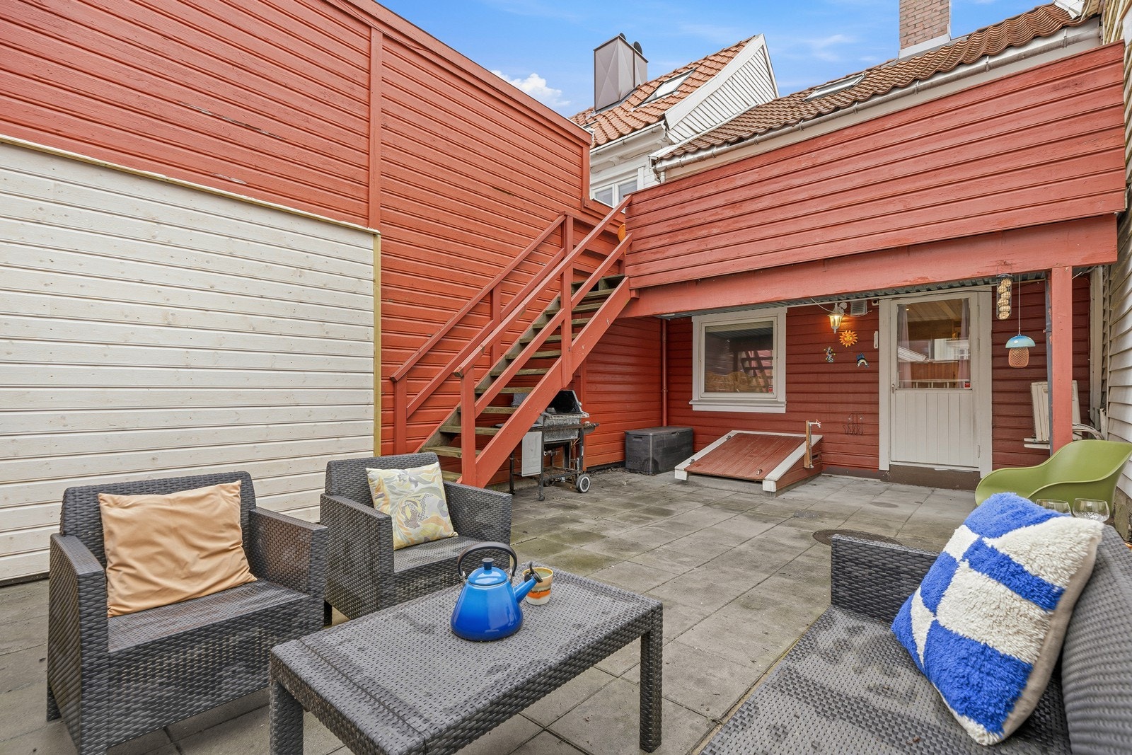 Under balkongen ligger en romslig terrasse med god plass til flere sittegrupper, grill og hyggelige uteaktiviteter Galleribilde