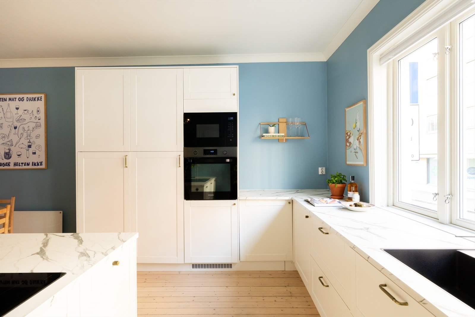 Kjøkkenet har en pen benkeplate med elegante marmordetaljer Galleribilde