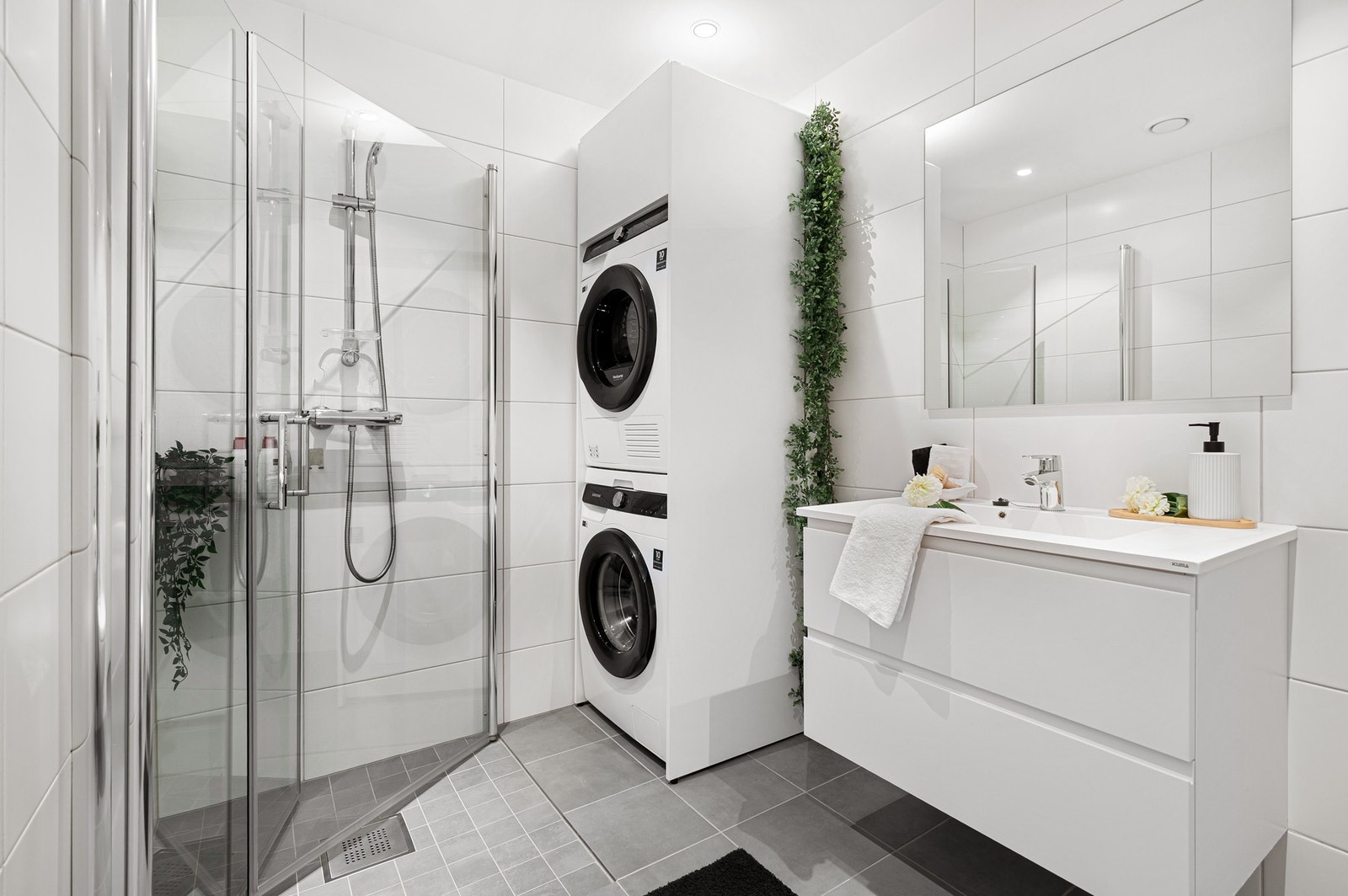 Badet er utstyrt med vegghengt WC, dusjhjørne med innfellbare dører og god plass til vaskemaskin og tørketrommel. Galleribilde