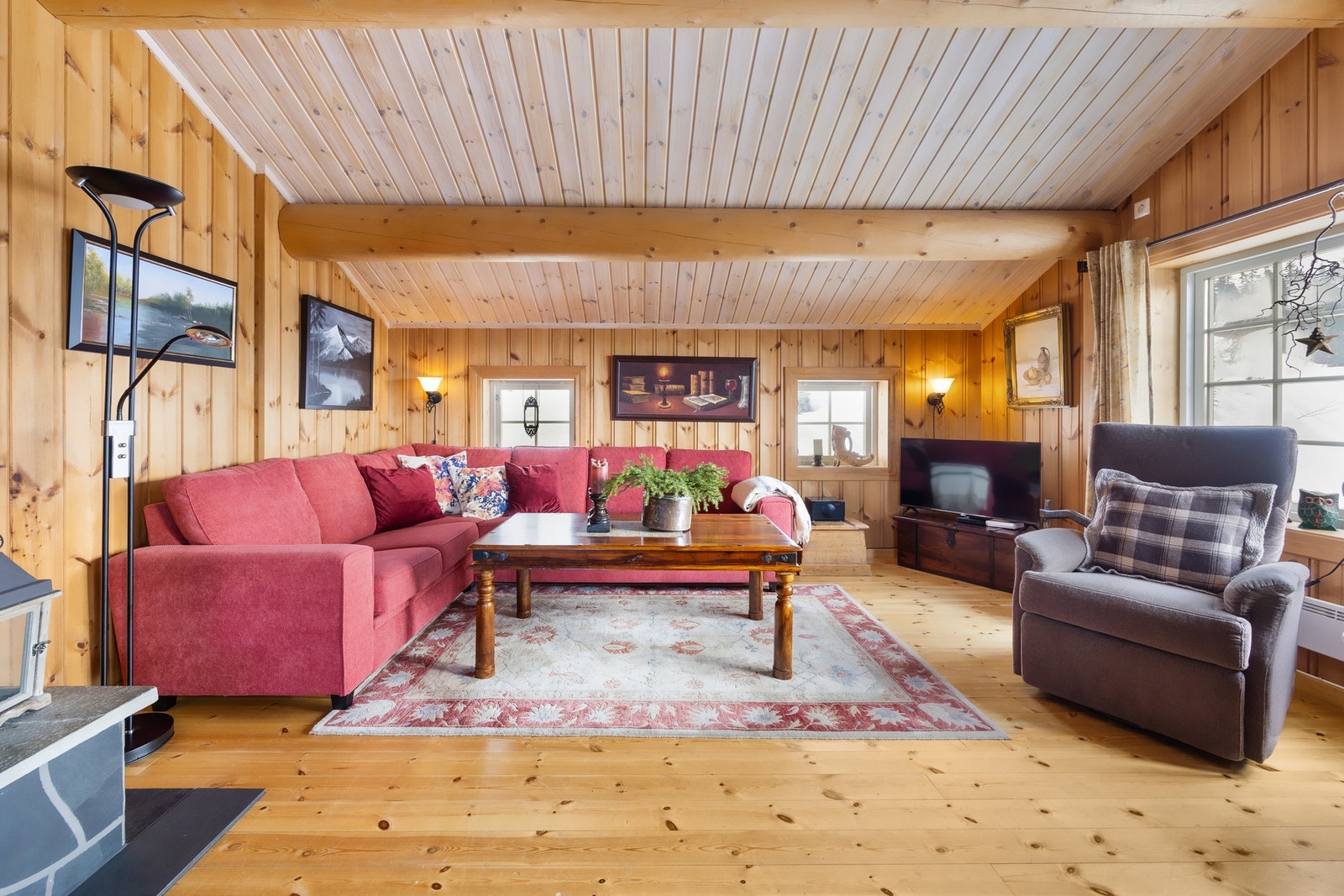 Stuen er det største rommet i fritidsboligen og har utgang til en solrik, sørvendt terrasse på ca. 31 m². Store vindusflater slipper inn rikelig med lys og den flotte takhøyden med synlige tømmerbjelker gir en svært luftig romfølelse. Galleribilde