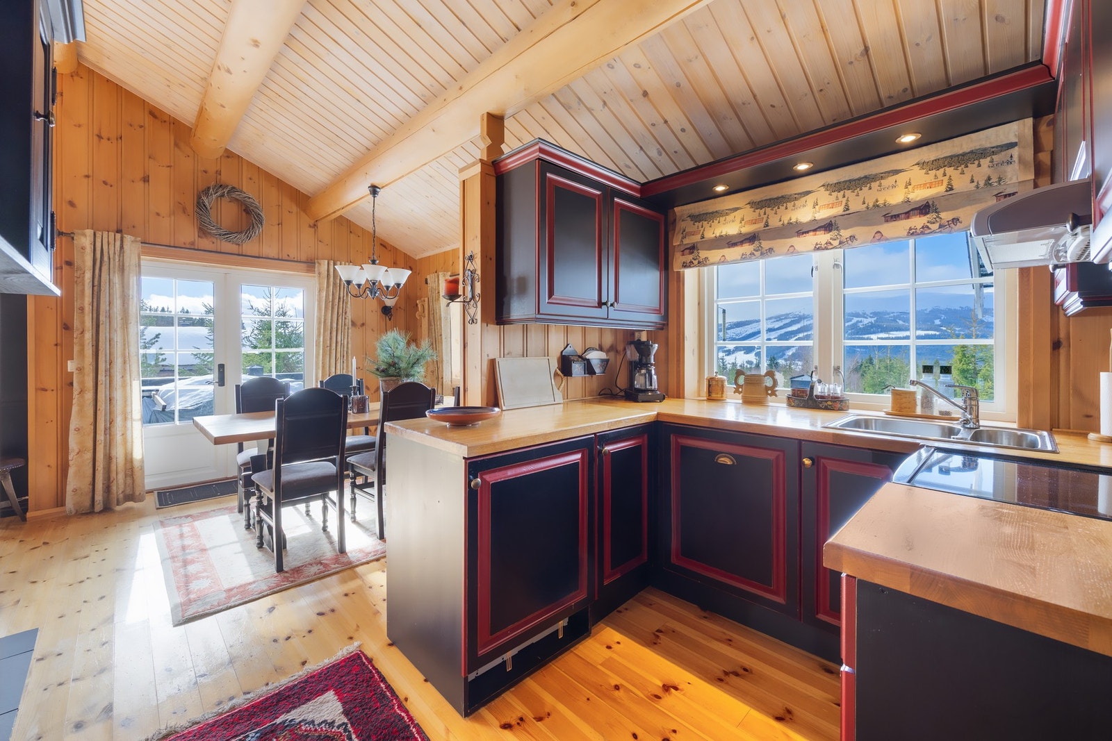 Kjøkkenet har integrerte hvitevarene som omfatter komfyr, oppvaskmaskin og kjøleskap, samt ventilator som er diskret plassert i overskap. Galleribilde