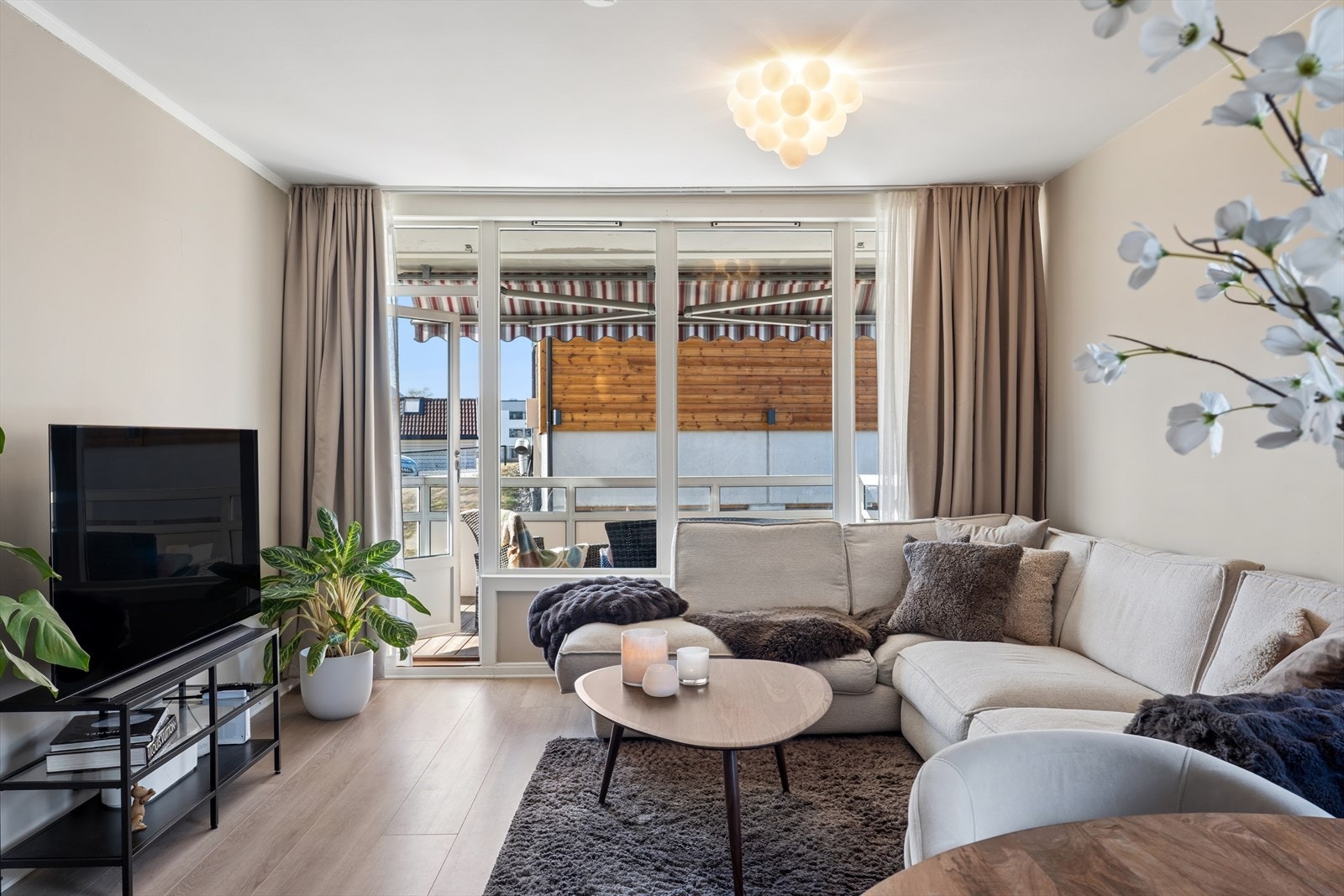 Stuen er et lyst og stilrent allrom med naturlig møblingssoner og godt med lysinnslipp Galleribilde