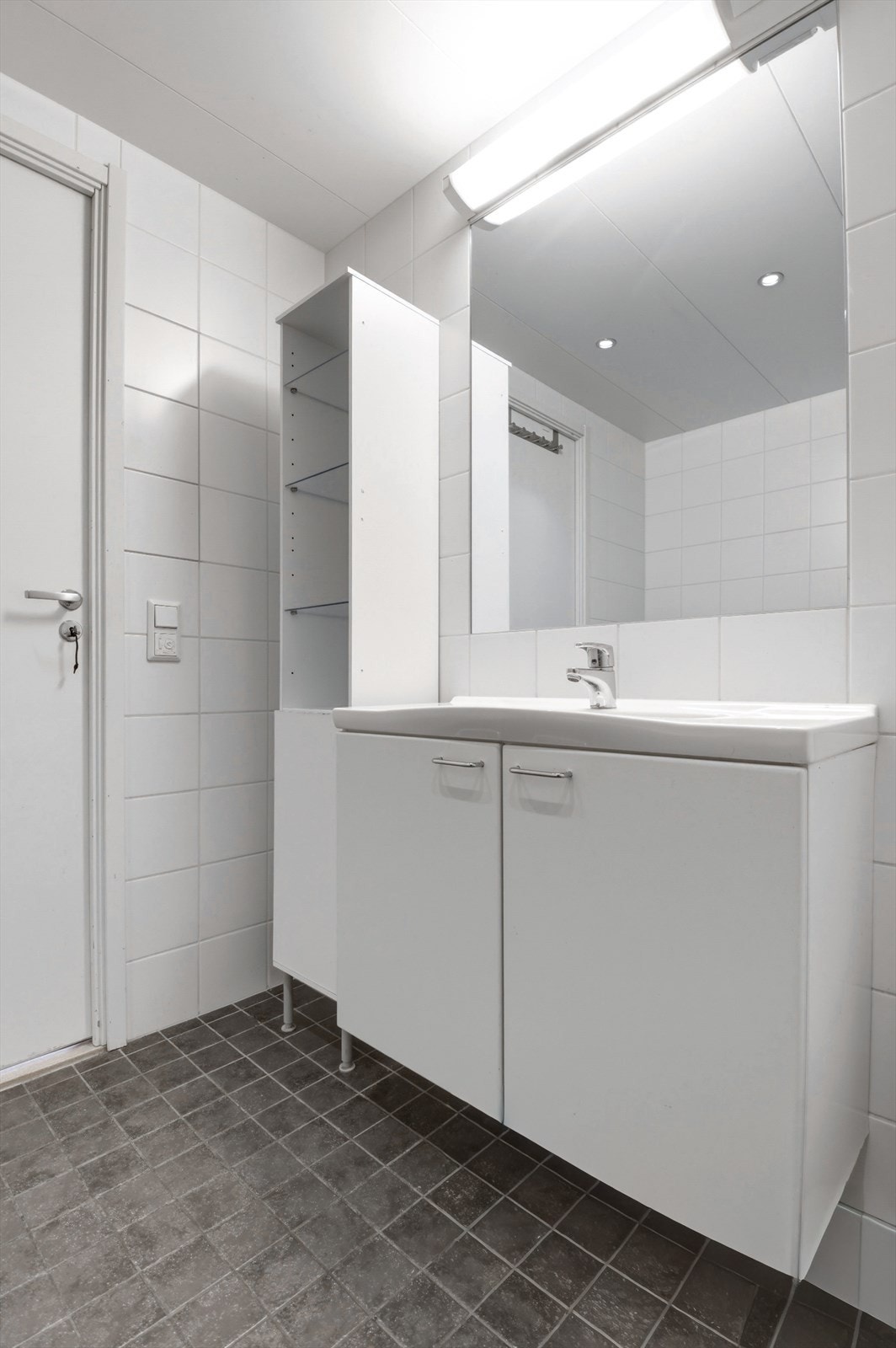 Innredningen består av servantskap med glatte fronter og heldekkende servant, speil, dusjhjørne med svingdører i glass og vegghengt toalett. Galleribilde