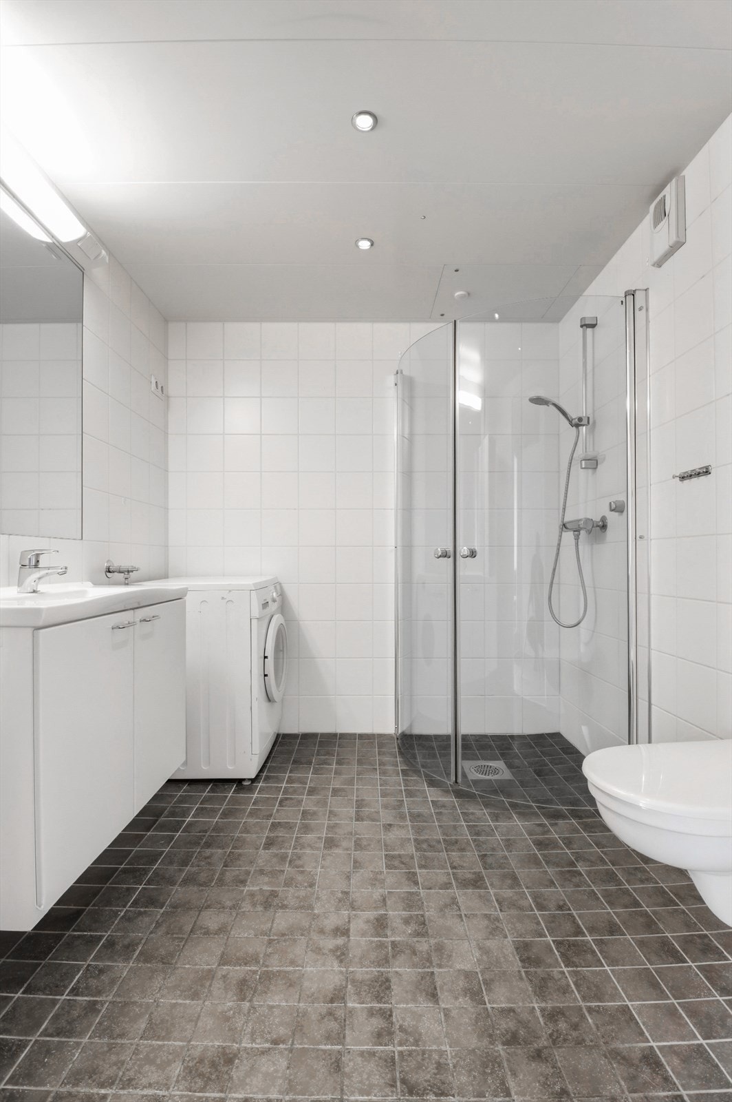 Badet har nøytrale, flislagte overflater, downlights i taket og elektrisk gulvvarme. Galleribilde