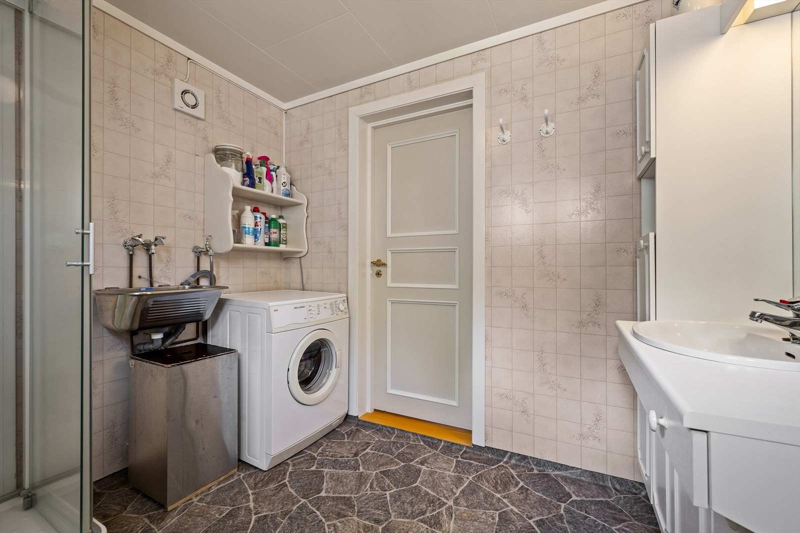 Badet inneholder dusjkabinett, servant med innredning, utslagsvask samt opplegg for vaskemaskin. Galleribilde