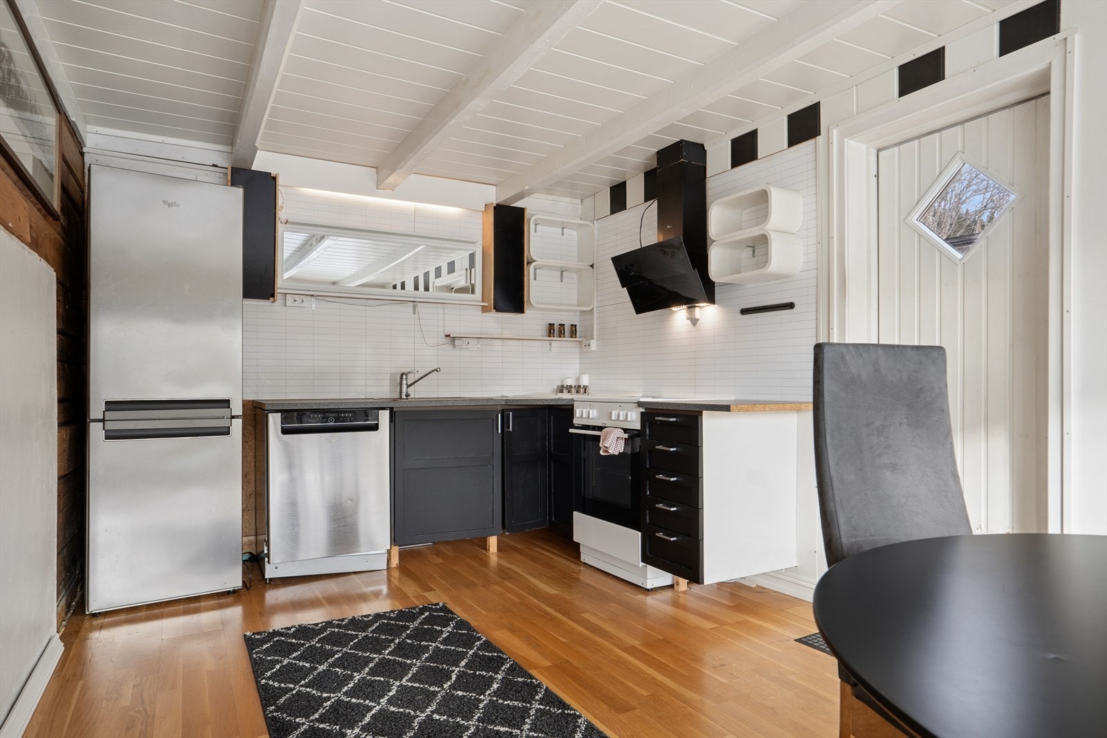 Kjøkkeninnredningen består av malte profilerte fronter, rustfritt benkebeslag og laminat benkeplate. Galleribilde