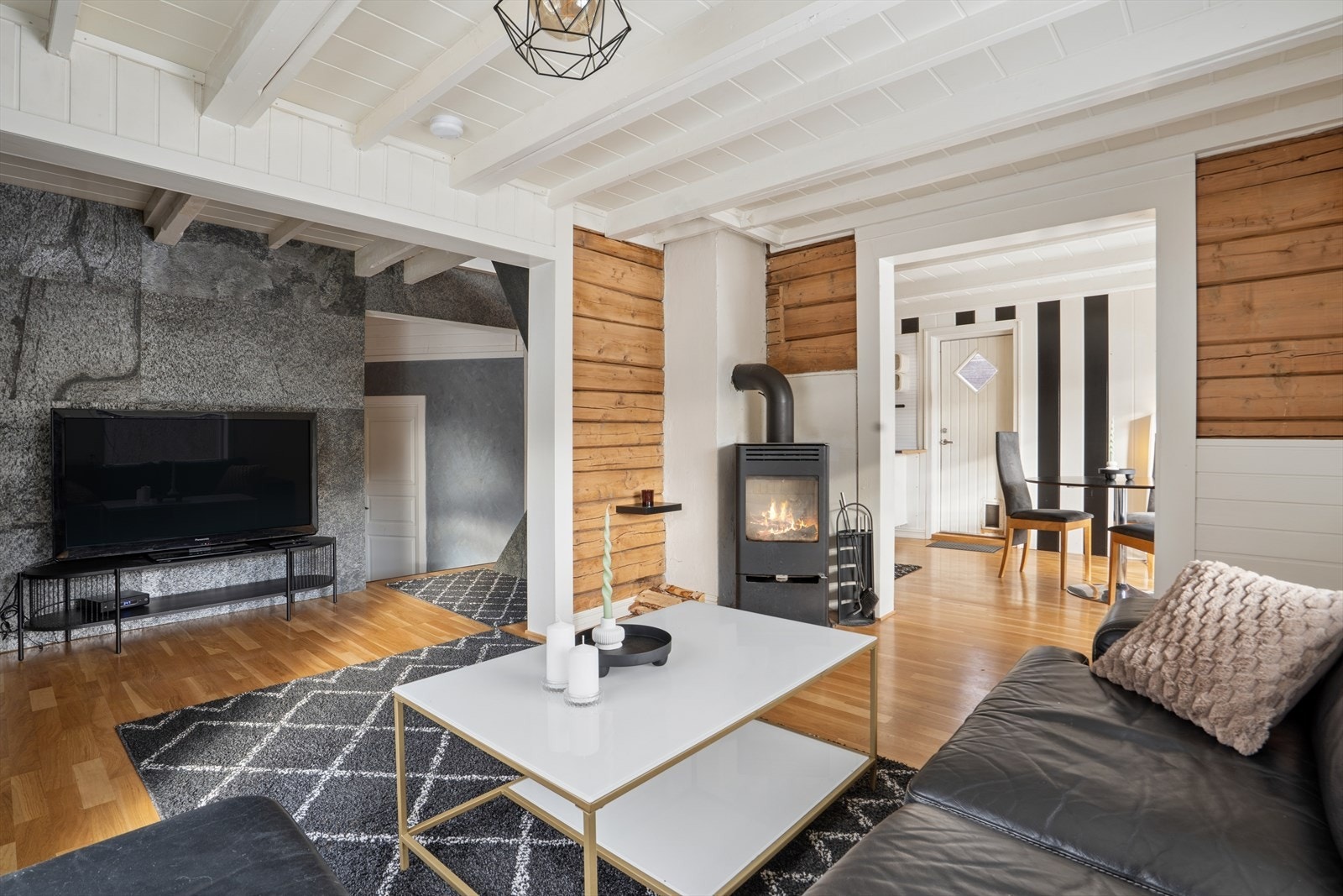 Det er i rommet etablert vedovn og plass til å ha sofa med tilhørende møblement. Galleribilde