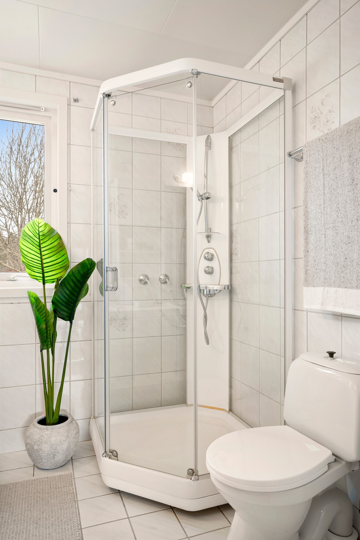 Videre er badet innredet med toalett og dusjkabinett i hjørne. Galleribilde